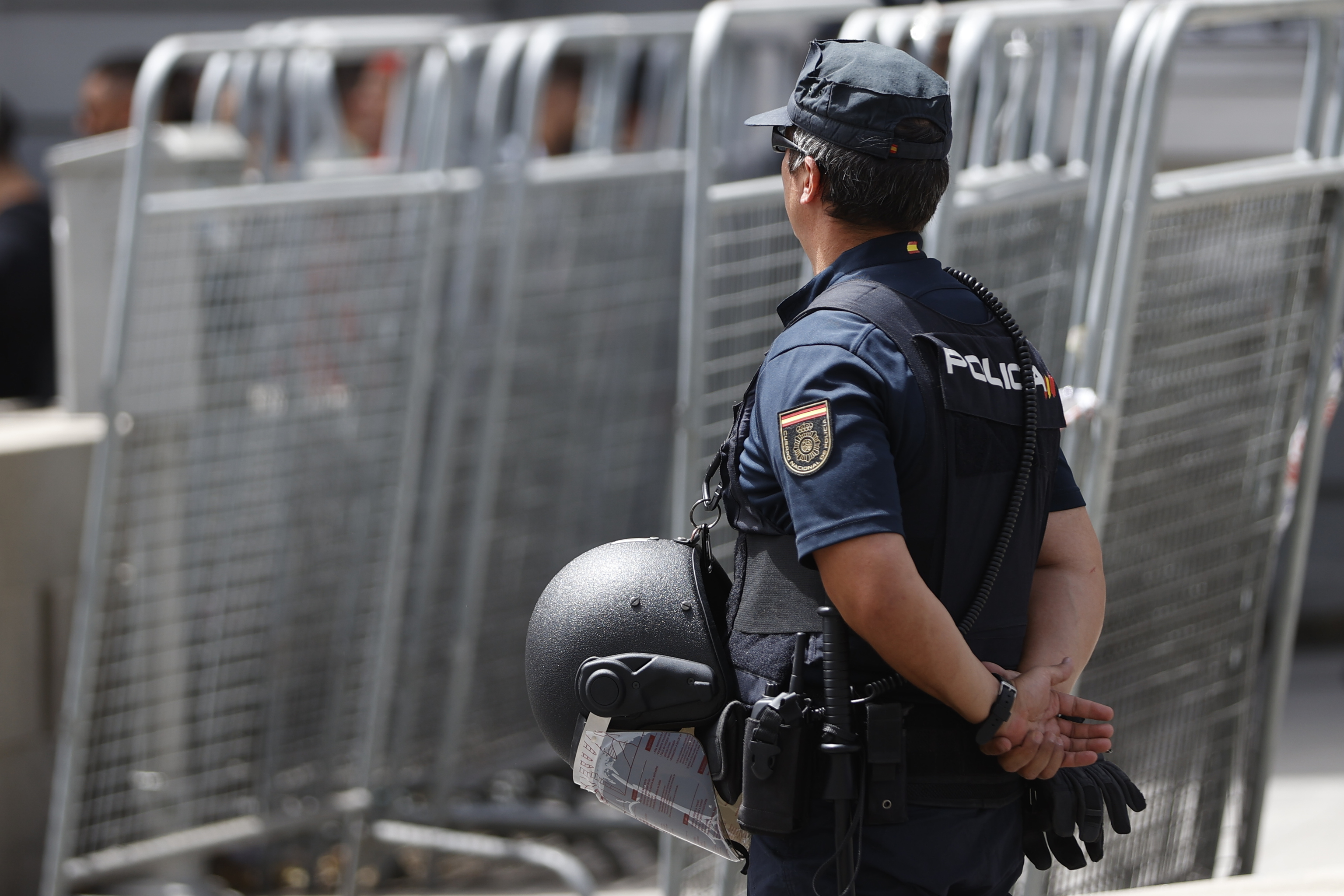 Un policía vigila junto a varias vallas de seguridad en Madrid, antes de la cumbre de la OTAN.