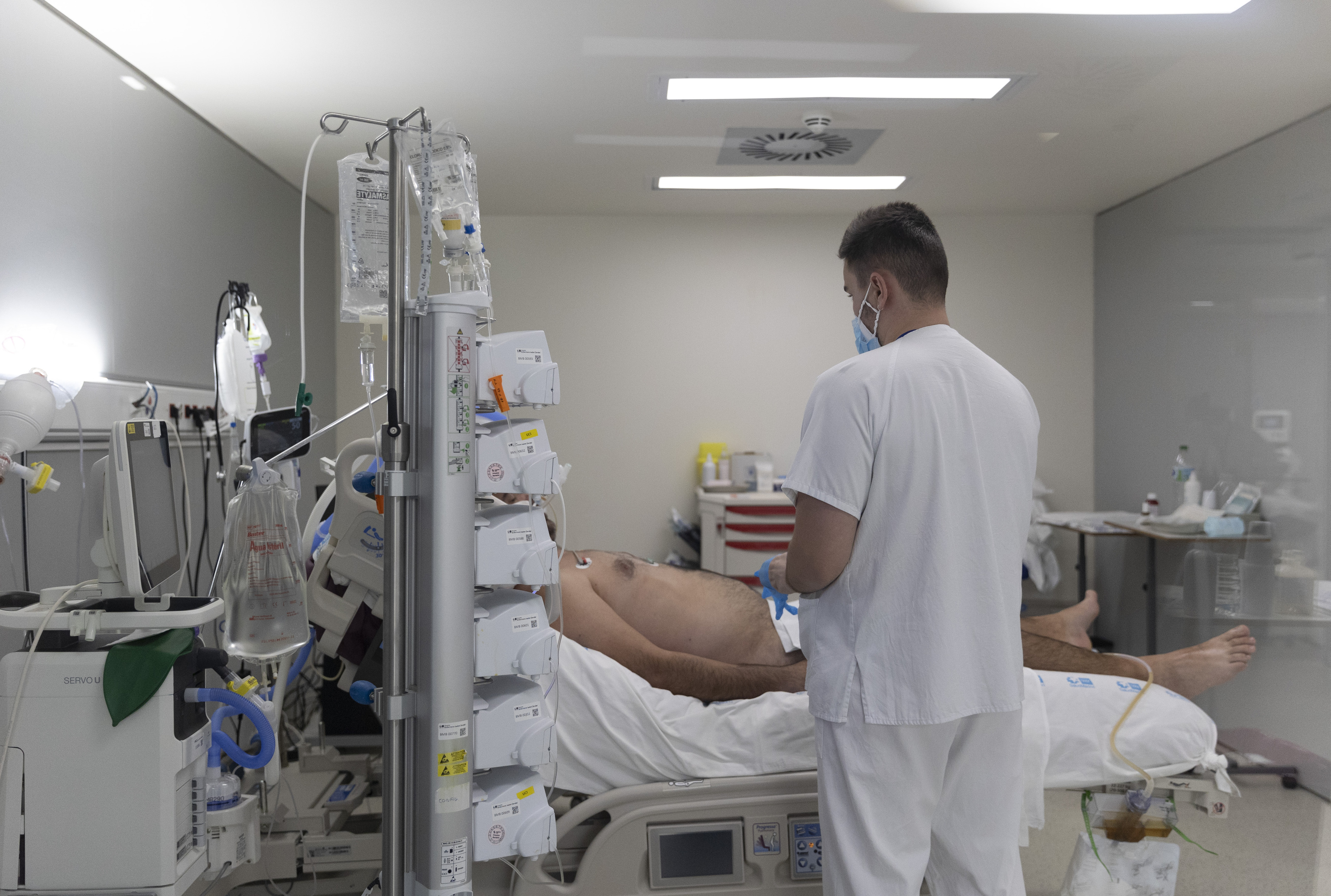Un sanitario alrededor de un paciente ingresado en la UCI del Hospital Enfermera Isabel Zendal, a 13 de enero de 2022, en Madrid