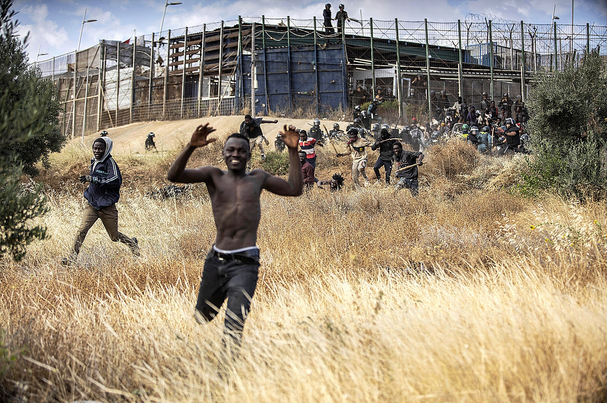 Un grupo de inmigrantes celebra su entrada en Melilla tras saltar la valla.
