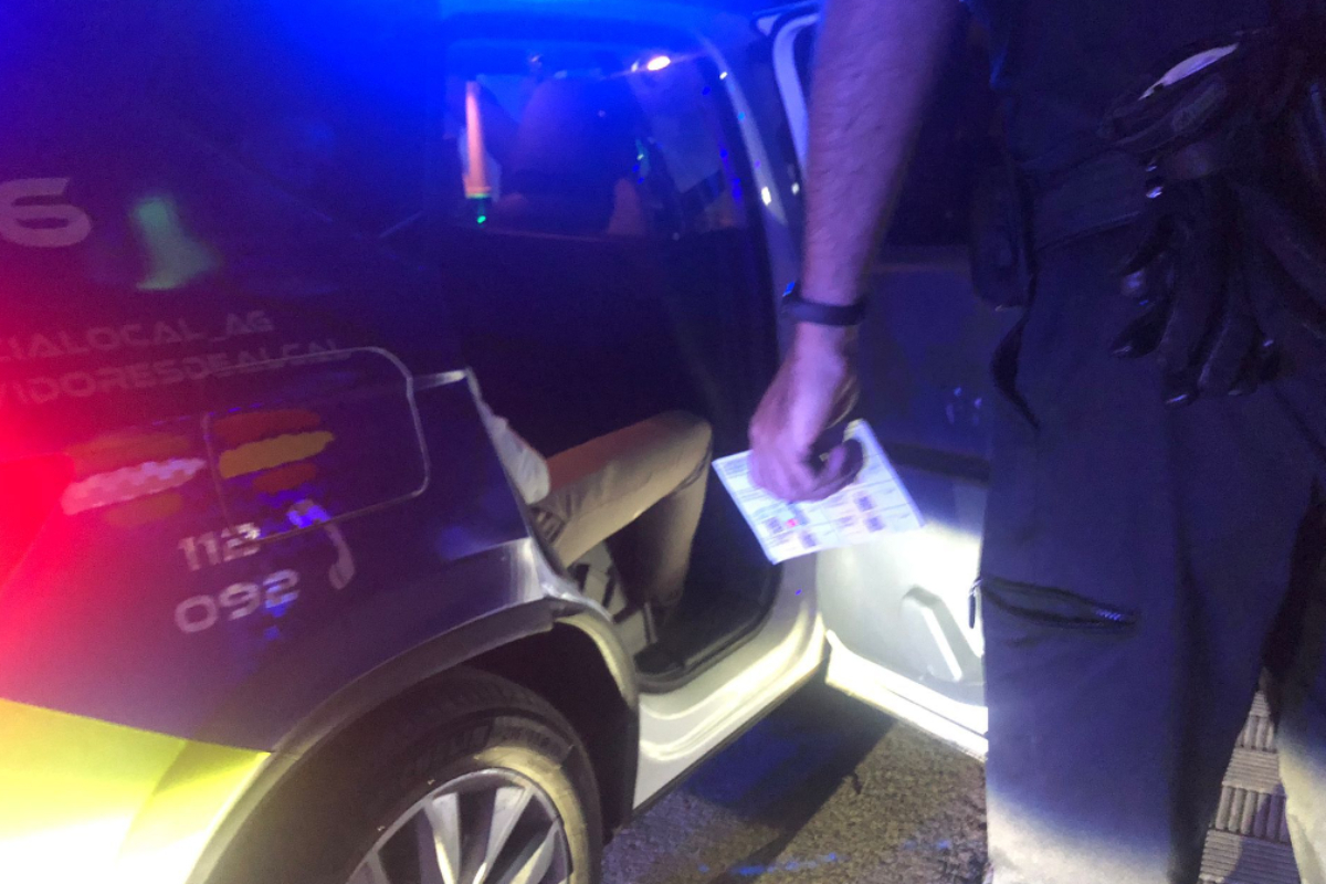 El detenido en el coche de la Policía de Alcalá de Guadaíra tras arrollar a varios clientes de un bar.