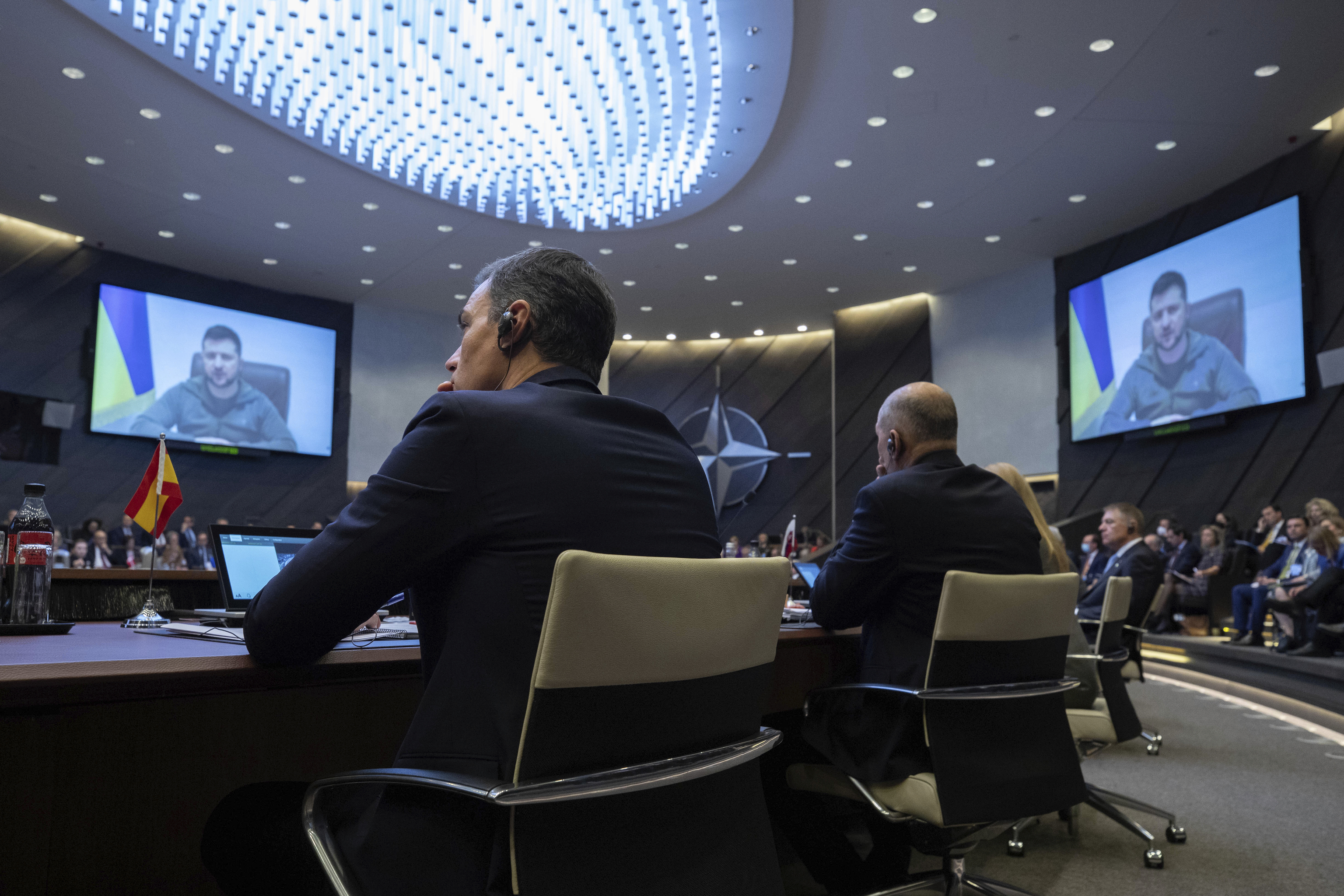Pedro Sánchez atiende a la intervención de Zelenski, durante la Cumbre Extraordinaria de la OTAN celebrada en Bruselas por la guerra en Ucrania, en marzo.