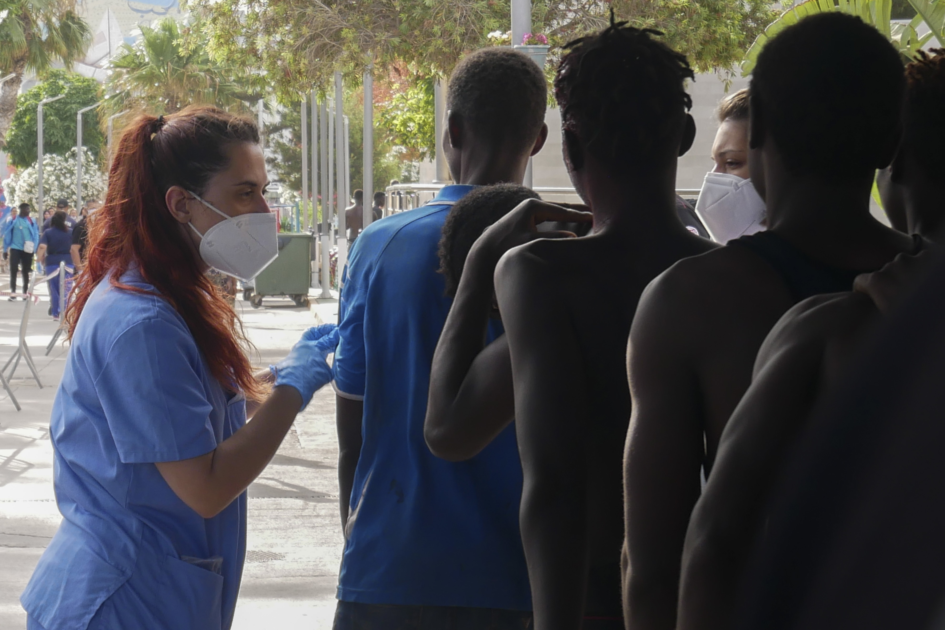 Una sanitaria examina a migrantes que lograron entrar en Melilla.
