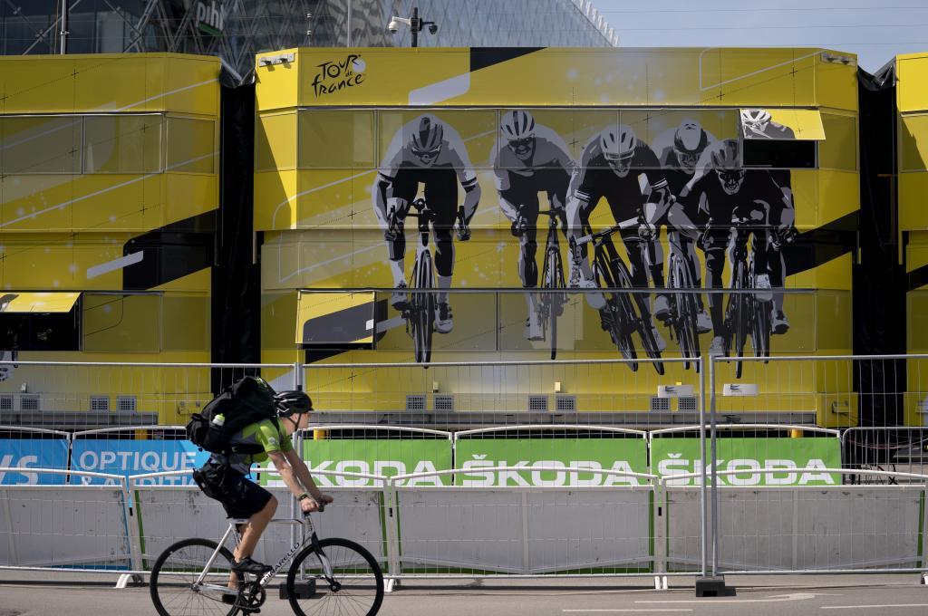 Un ciclista pasa delante del cartel del Tour en Copenhague.