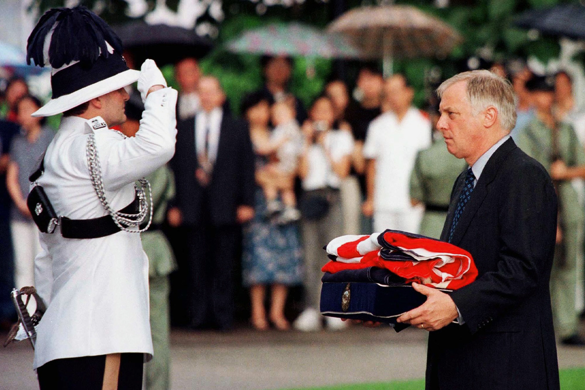 Chris Patten recibe la bandera británica después de que se bajara por última vez en Hong Kong el 30 de junio de 1997.