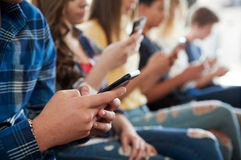 Un grupo de adolescentes utiliza su telfono mvil.