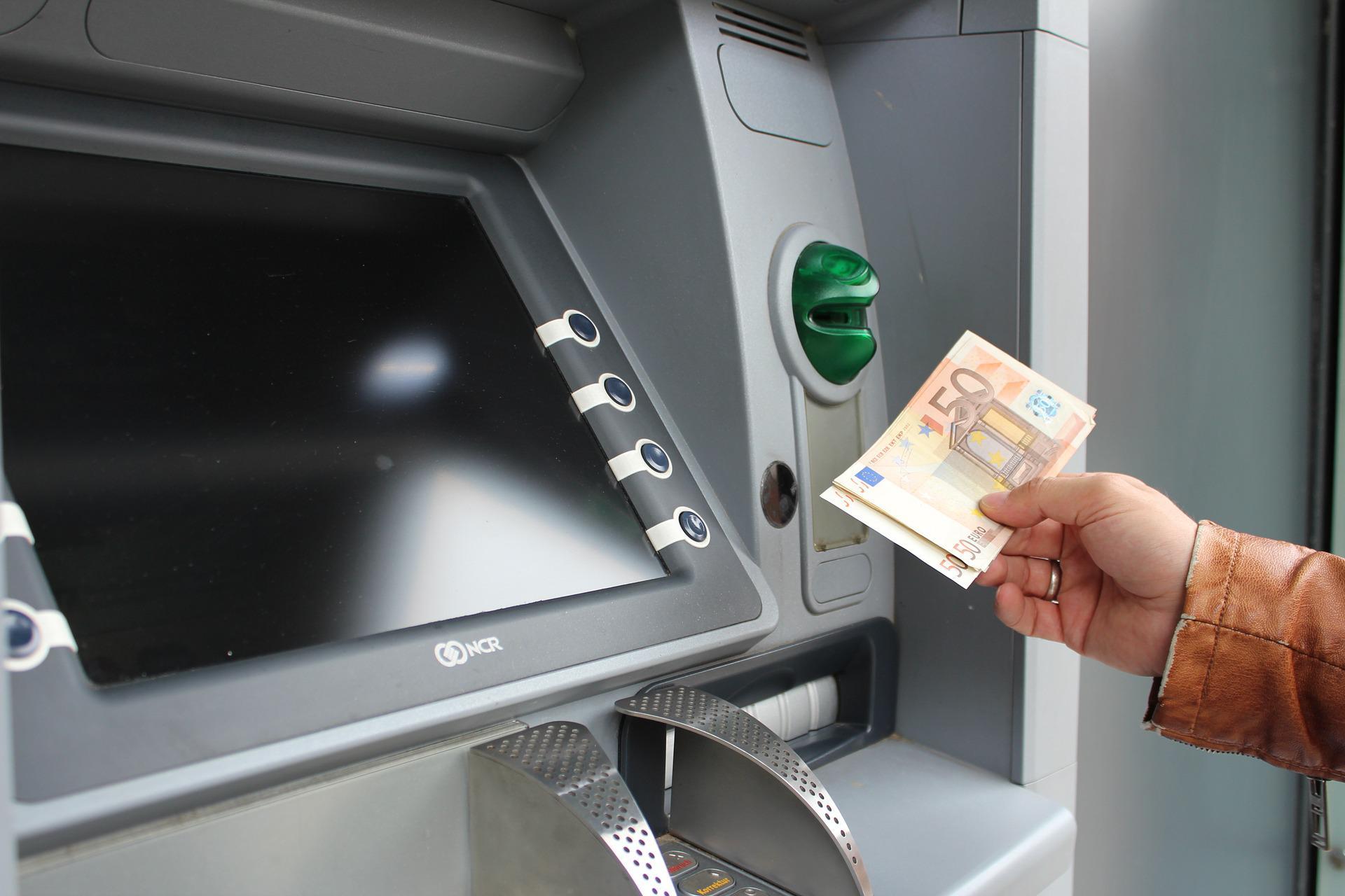 Una persona retira dinero de un cajero automático.
