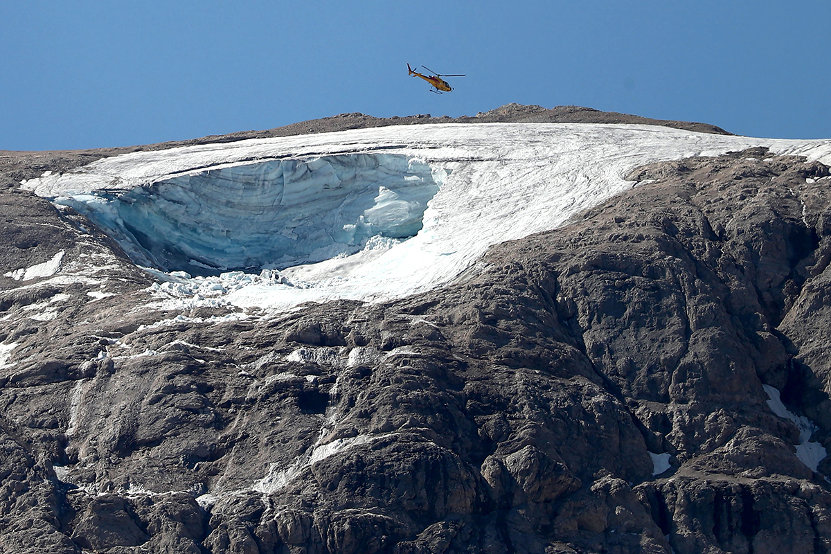 Un helicóptero busca a los 20 senderistas desaparecidos tras el desprendimiento de un glaciar de la Marmolada.