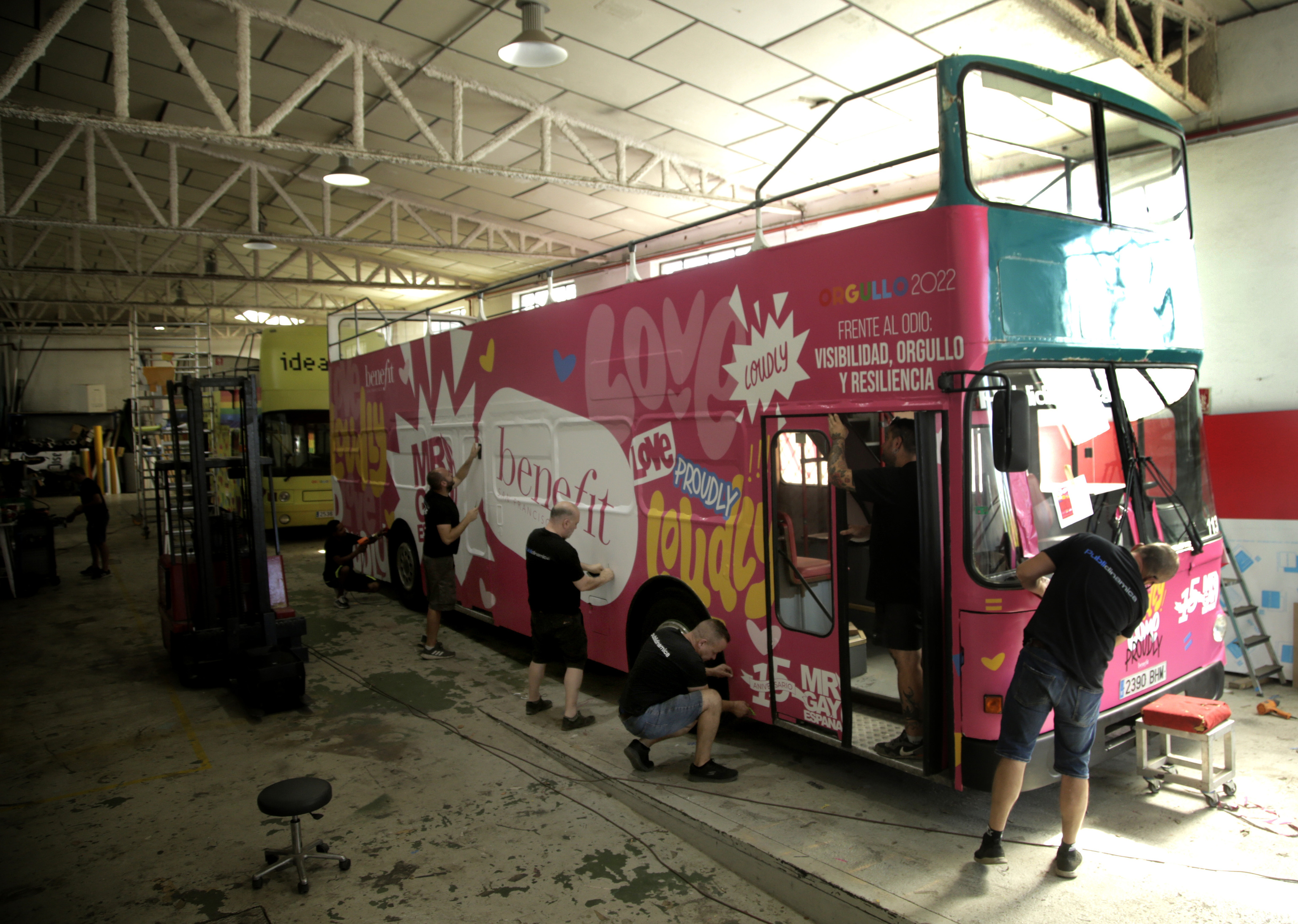 Varios operarios decorando un autobús.