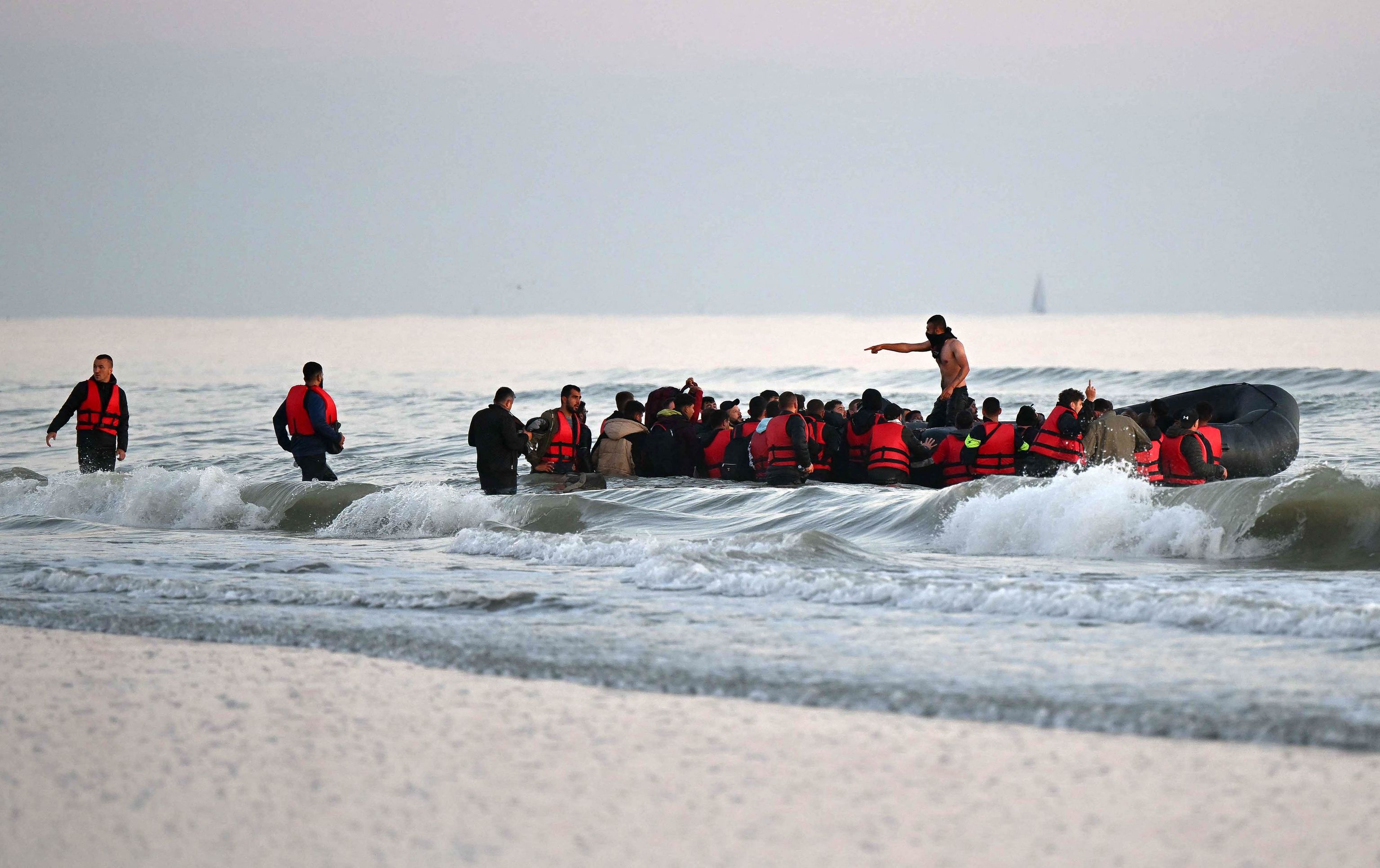 Inmigrantes abordan un bote inflable en Francia para llegar al Reino Unido.