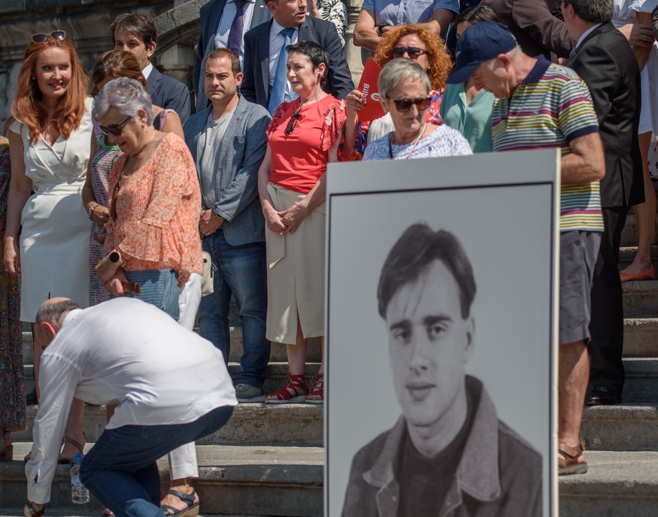 Jone Goirizelaia, con blusa roja, participa en la concentración por Blanco en Bilbao cuya fotografía sujetan dos vecinos en las escalinatas del Ayuntamiento.
