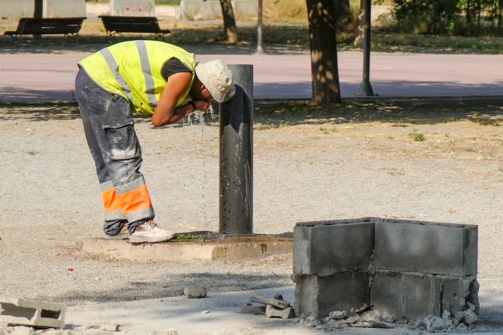 Un trabajador se refresca en un fuente de un parque de Lleida, el pasado viernes en plena ola de calor.