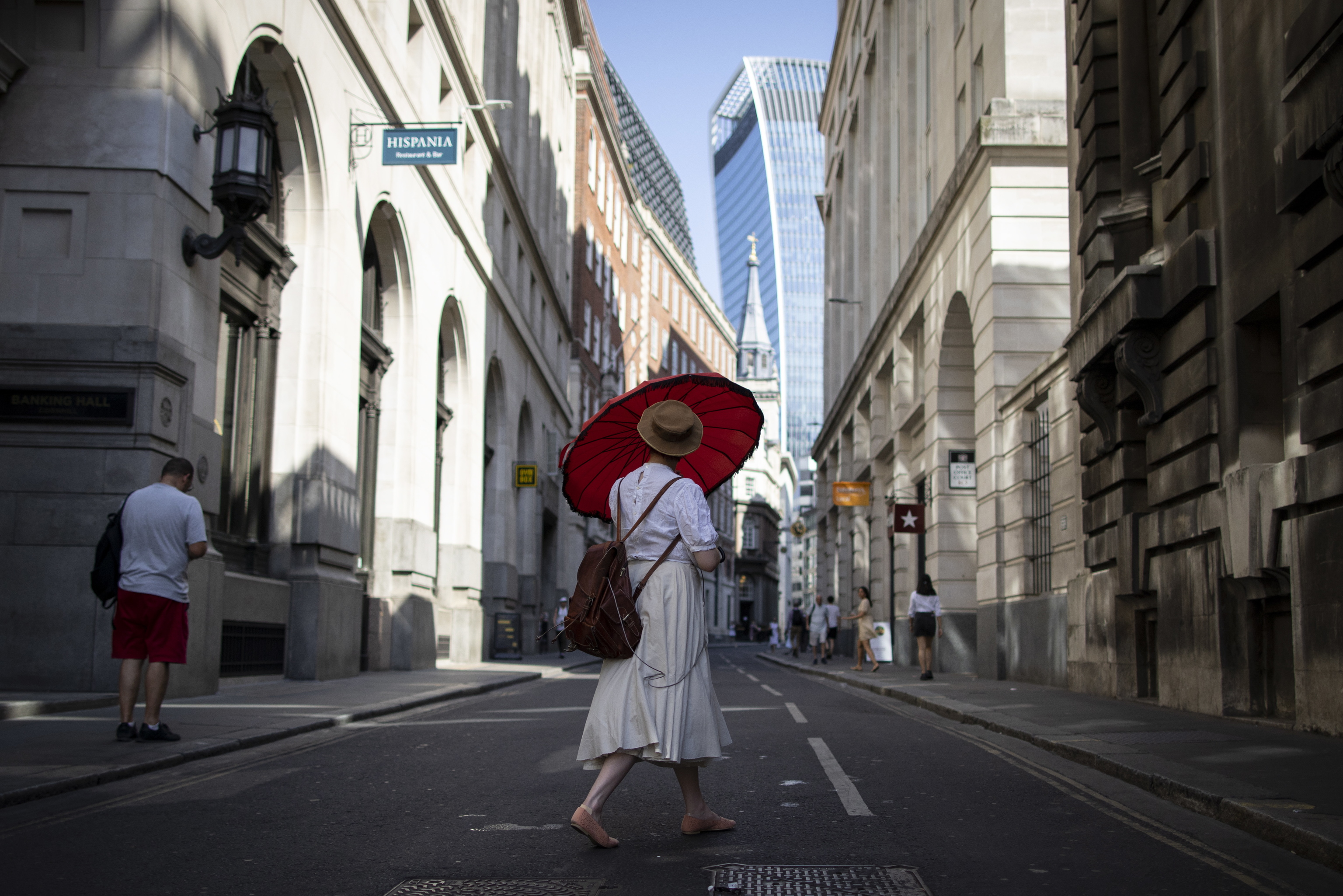 Una mujer, con un paraguas en Londres ante el calor.