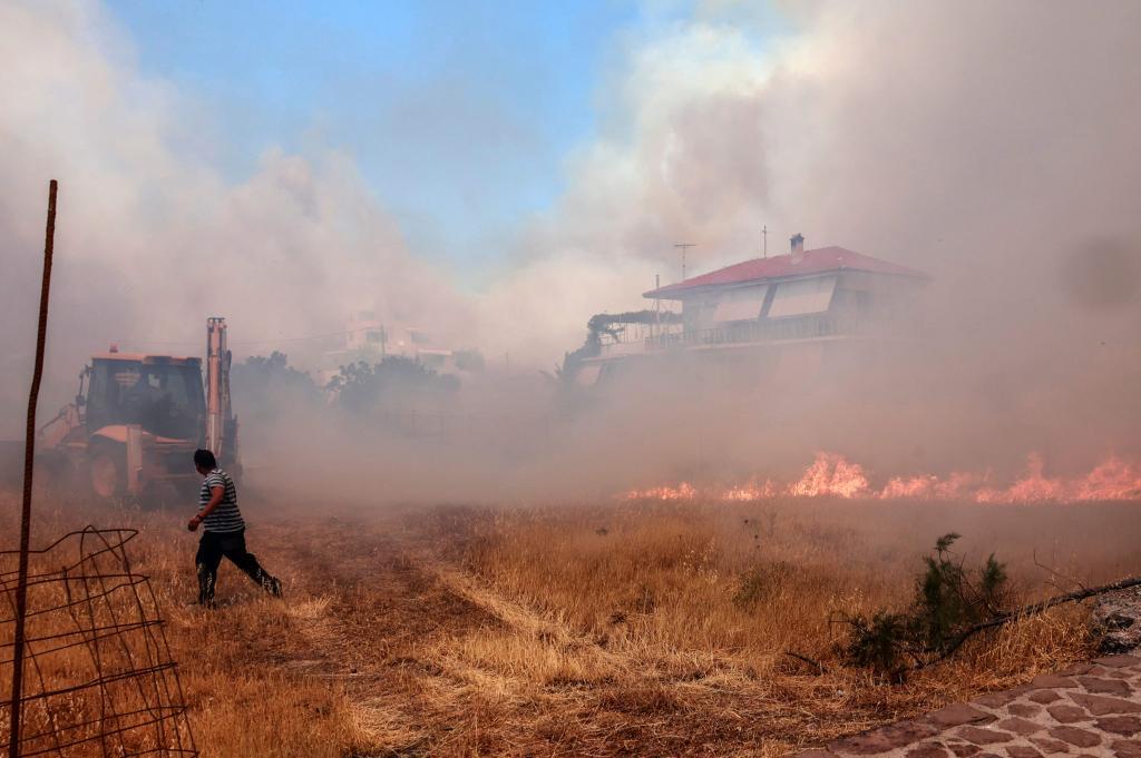 Turistas y residentes, evacuados de un popular centro turístico de Lesbos por un incendio que ha alcanzado las viviendas