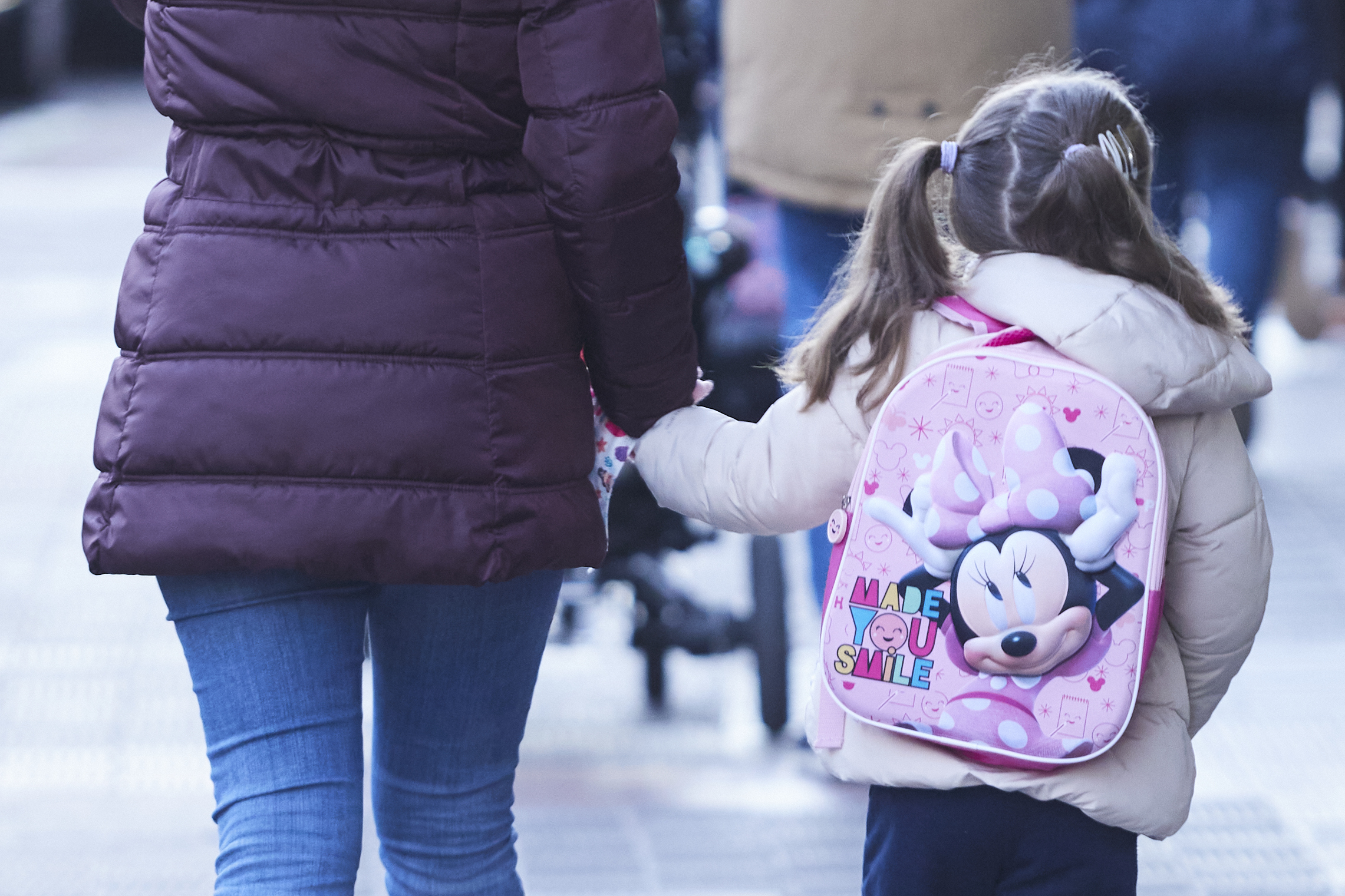 Una niña acompañada de un adulto acude al colegio en Sevilla.