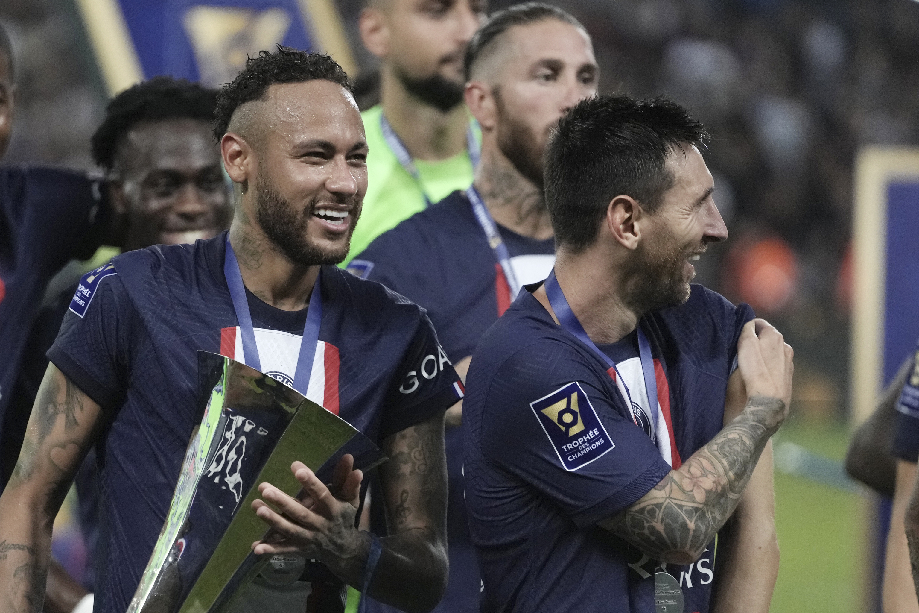 Neymar muestra el trofeo de la Supercopa junto a Me+ssi y Ramos (detrás), entre otros jugadores del PSG.