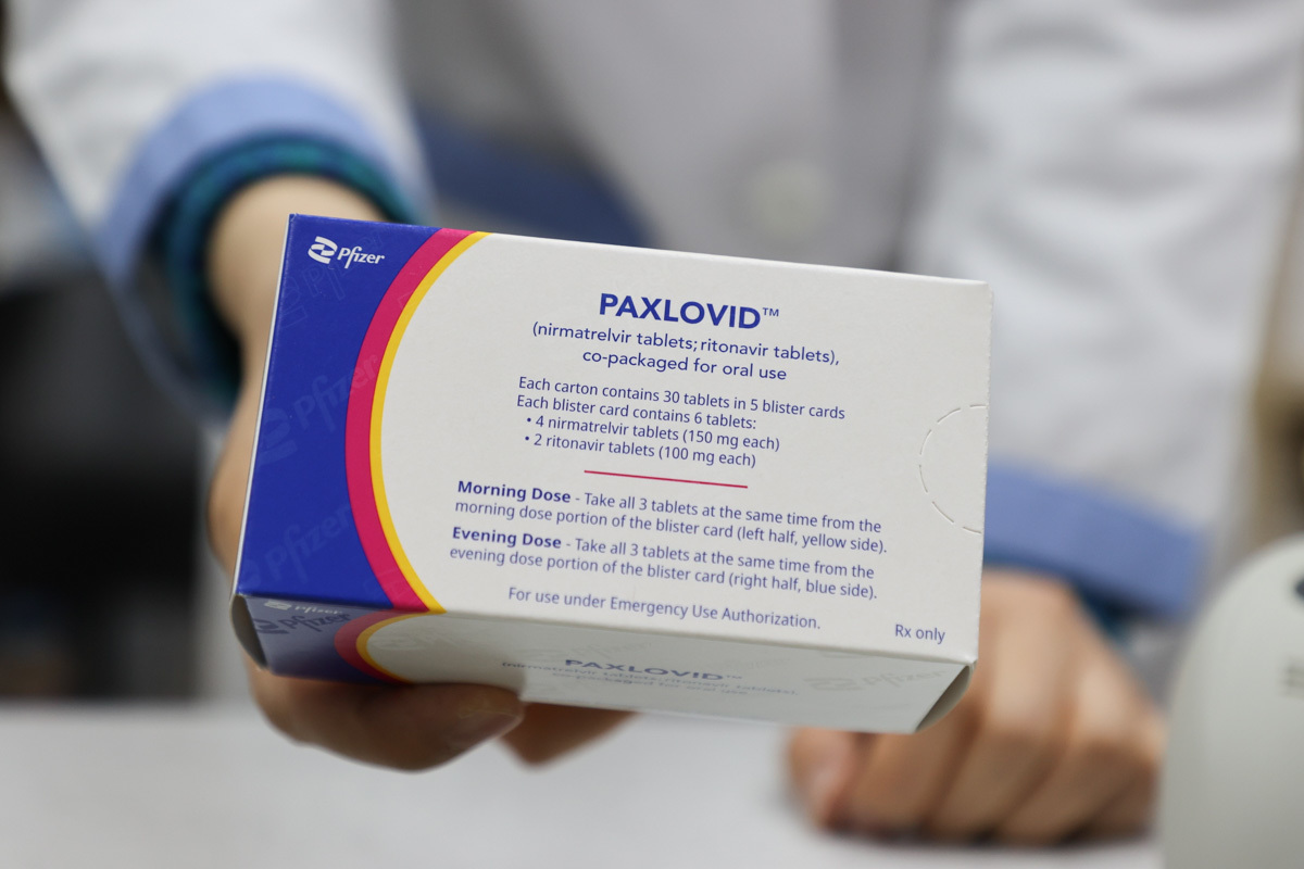 Un farmacéutico sujeta una caja con el tratamiento antiviral.