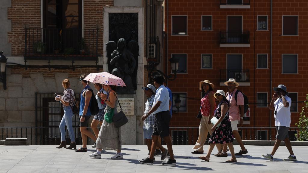 Turistas protegiendose del sol en Madrid.