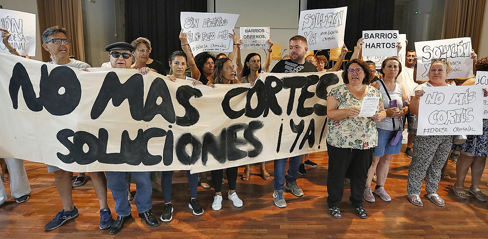 Vecinos afectados por los apagones en los barrios más deprimidos de Sevilla portan una pancarta reivindicativa en el Centro Cívico La Plata, donde mantienen un encierro indefinido.