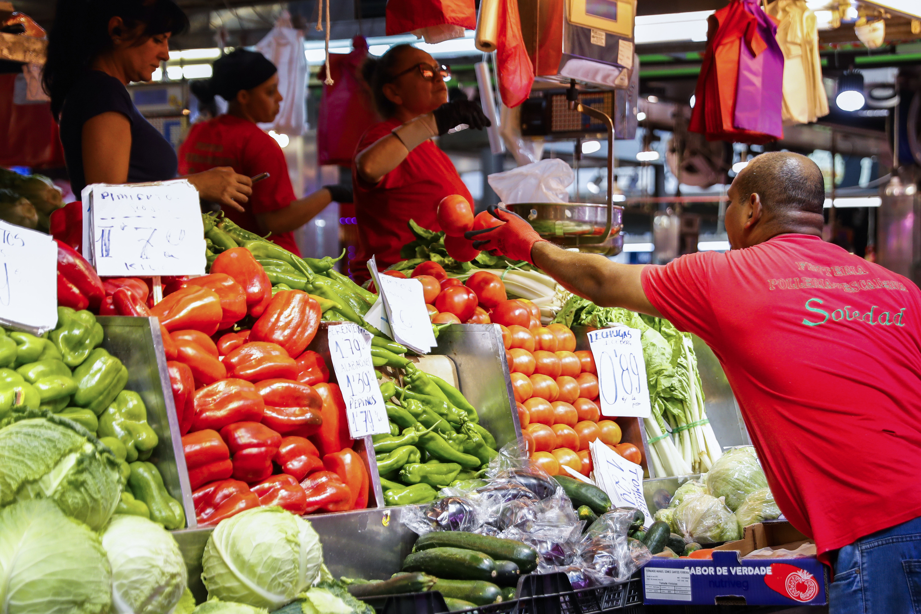 Un hombre compra en un puesto de fruta y verduras de un mercado de Madrid.