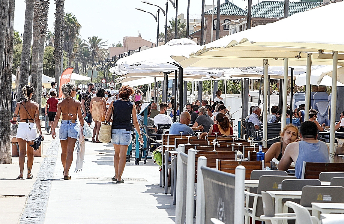 Turistas disfrutan de las terrazas de una localidad costera valenciana.