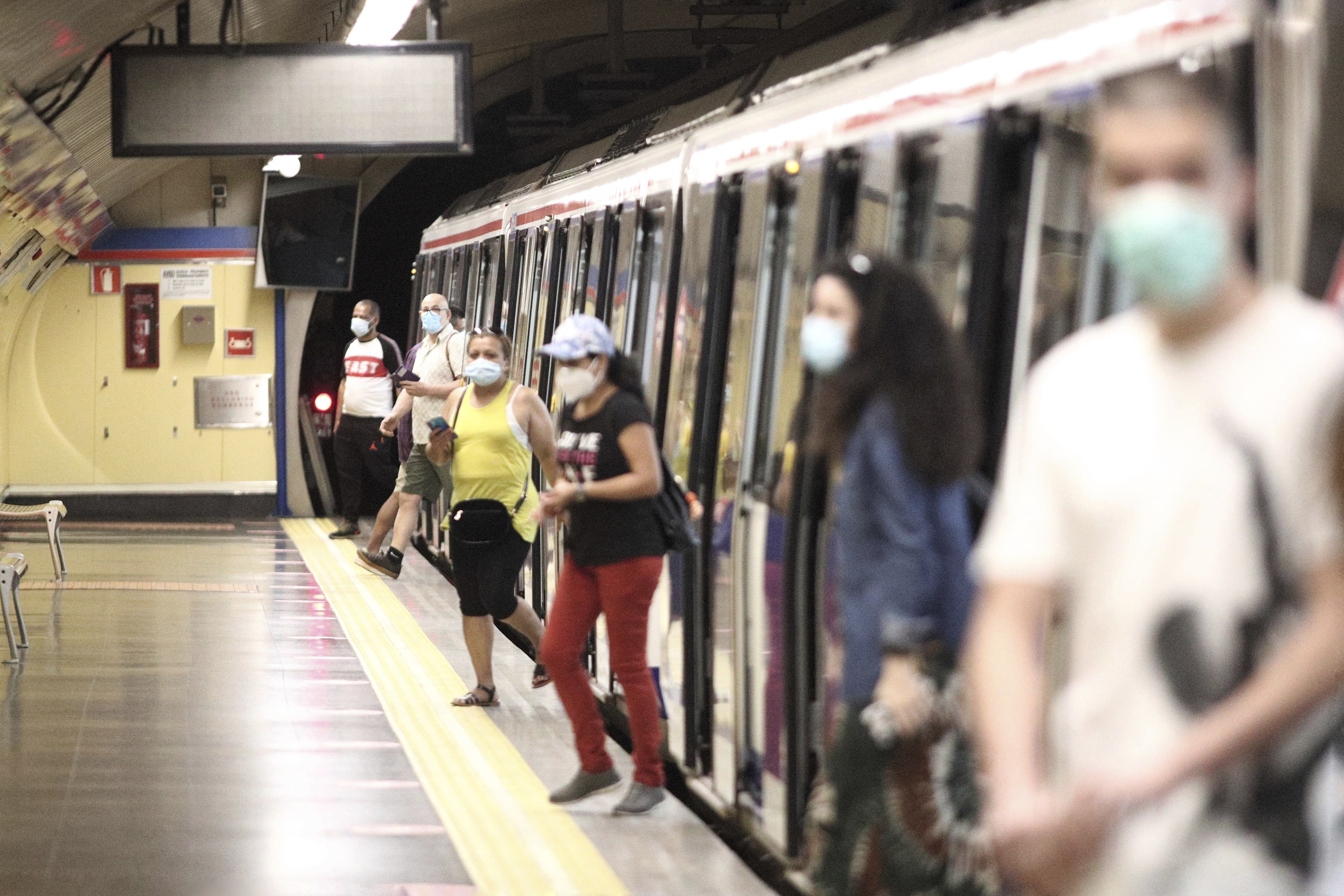 Personas con mascarilla bajando del metro