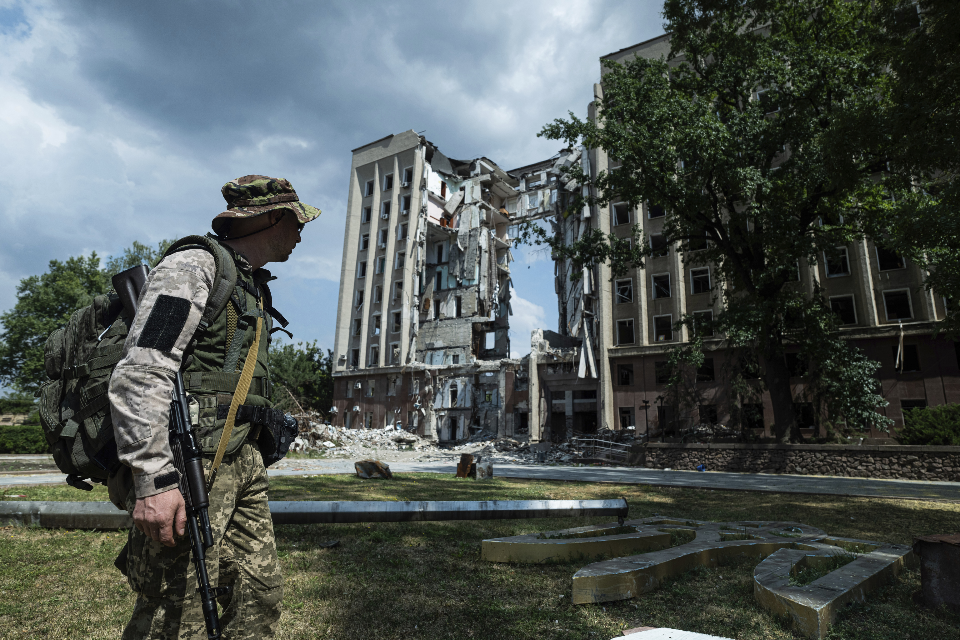 A Ukrainian soldier walks past an attacked building in Mikolayev.