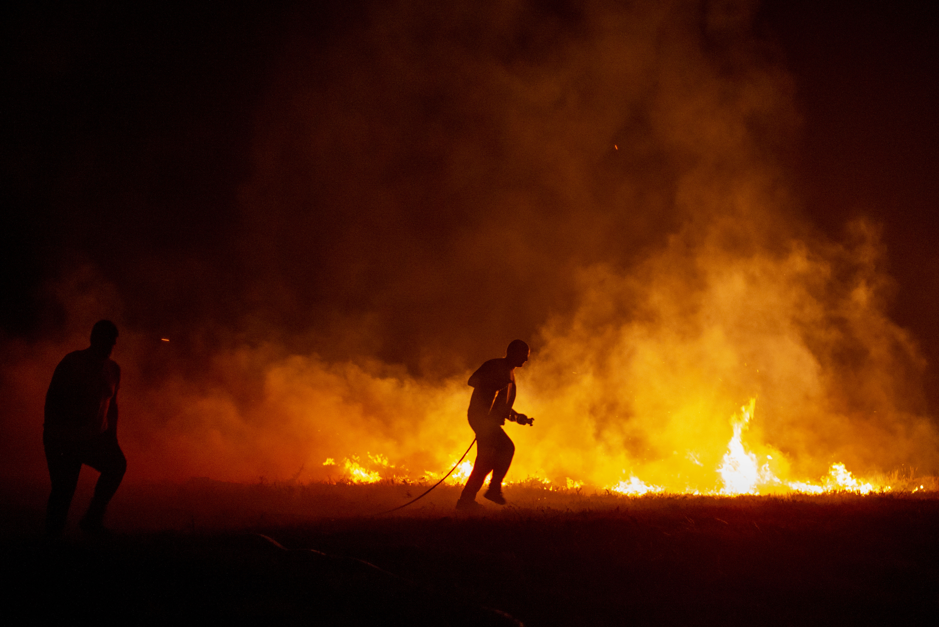 Un bombero lucha contra el fuego de madrugada en Boiro