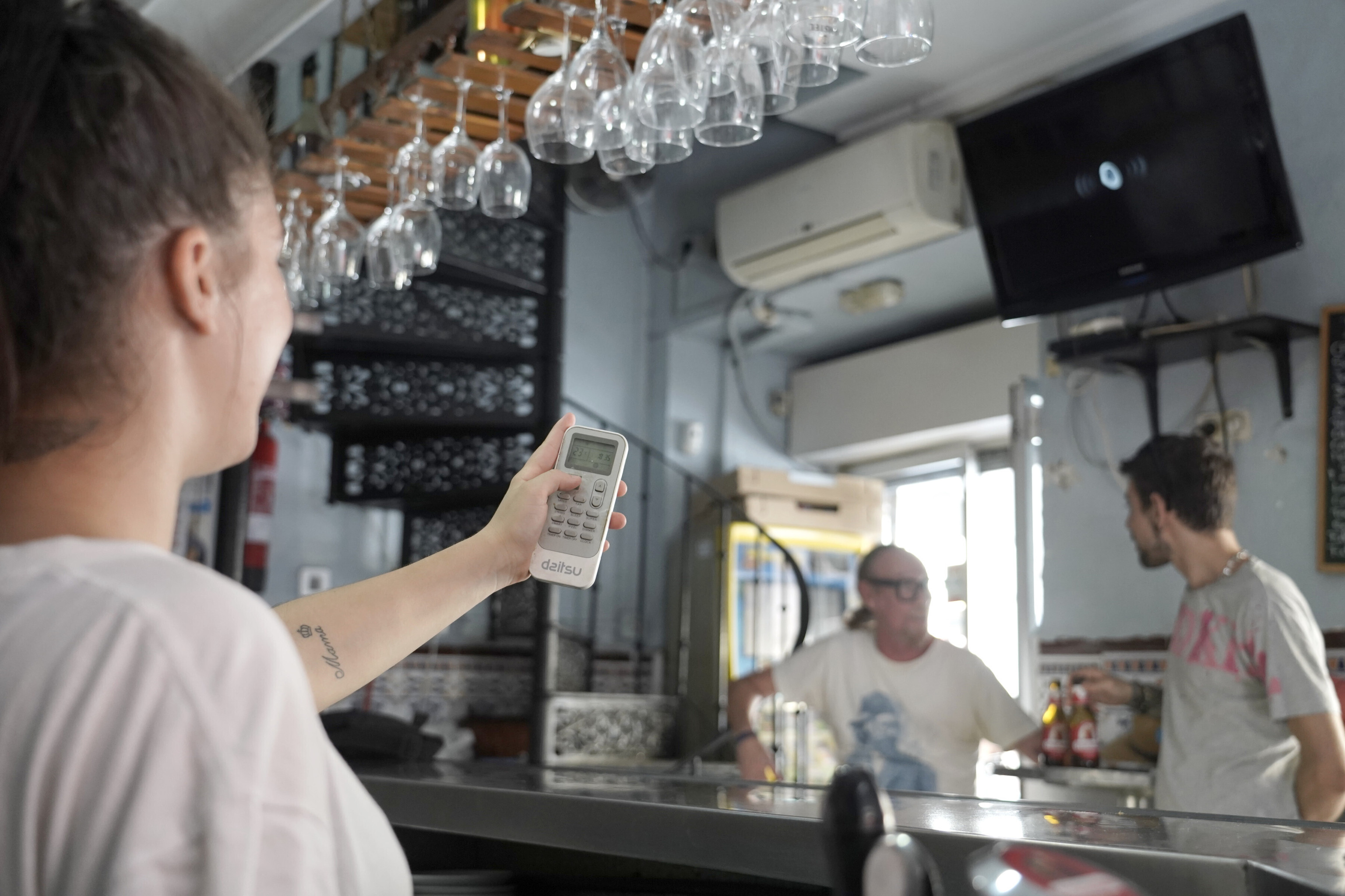 Una trabajadora de un bar en el centro de Sevilla regula el aire acondicionado.