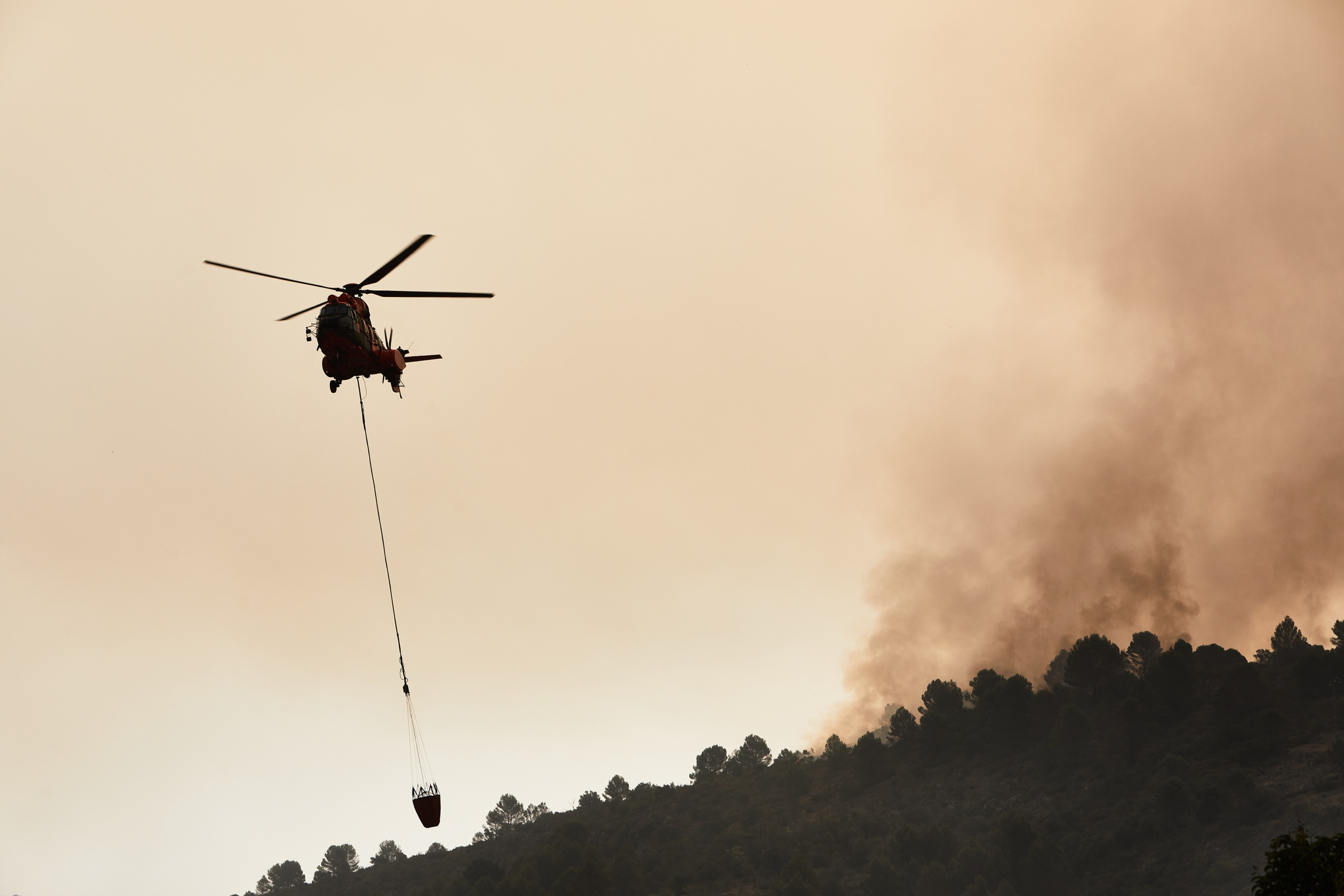 Un helicóptero sobrevuela uno de los focos del incendio forestal declarado en la en Vall d'Ebo (Alicante). Dos medios aéreos se han incorporado a primera hora de este domingo a los trabajos de extinción del incendio forestal declarado a última hora de ayer.