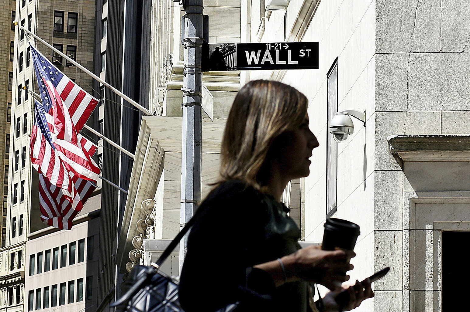 Una mujer camina cerca del edificio que alberga la Bolsa de Nueva York.