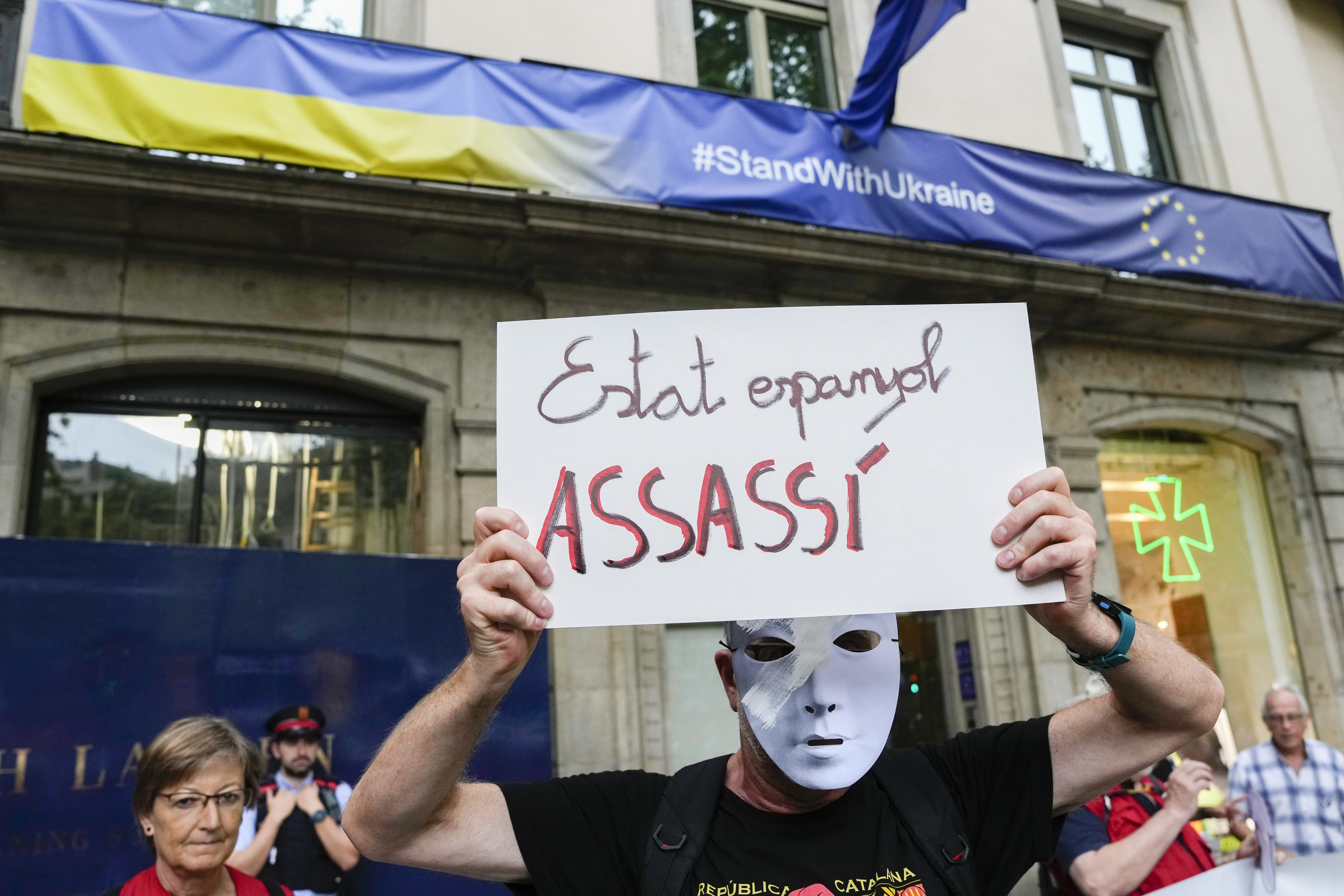 Un manifestante independentista sostiene una pancarta en la que se lee: "Estado español asesino".