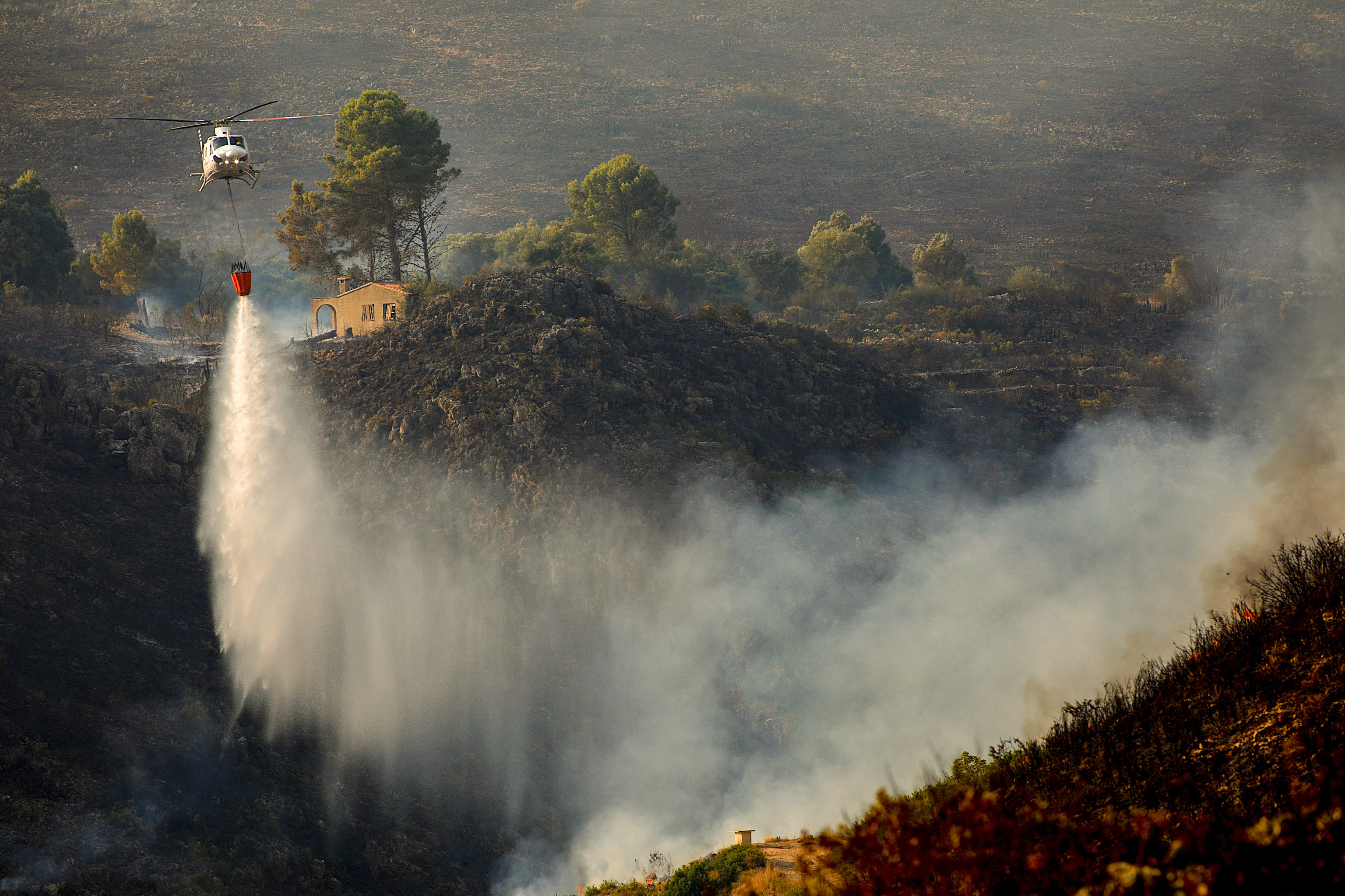 Un helicóptero descarga agua en la Vall d'Ebo.