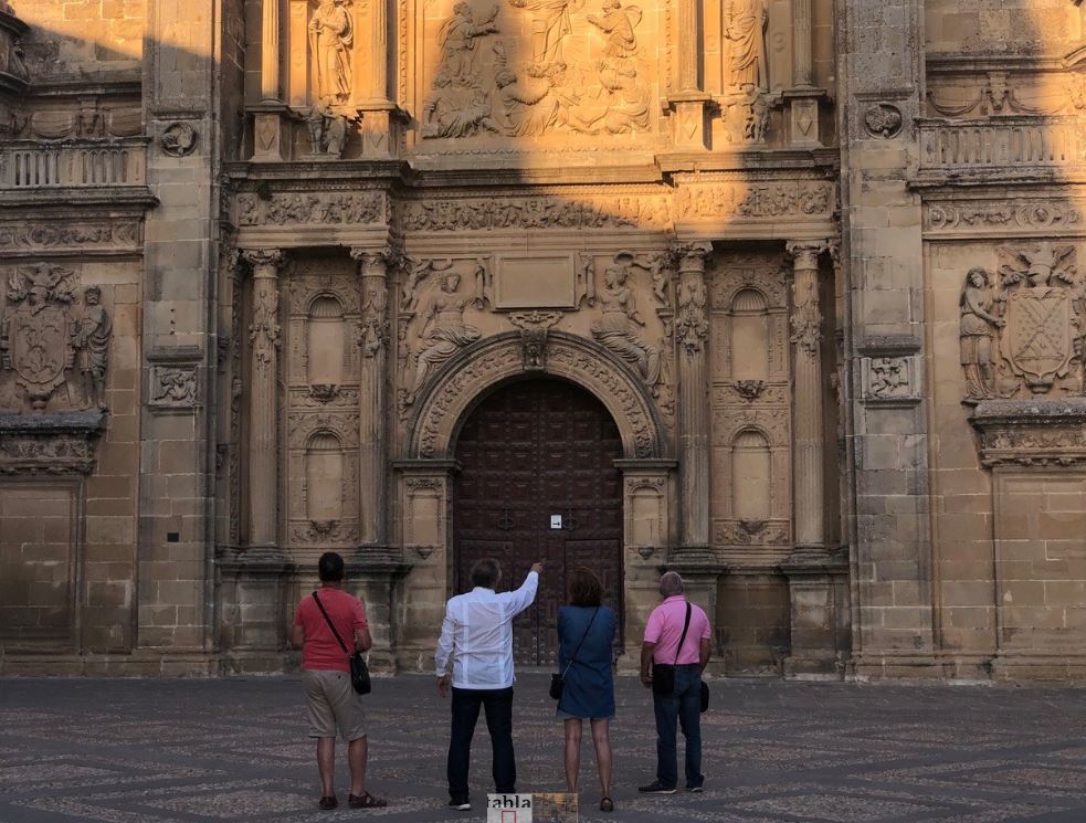 Unos viajeros contemplan la fachada renacentista de la capilla de El Salvador de beda.