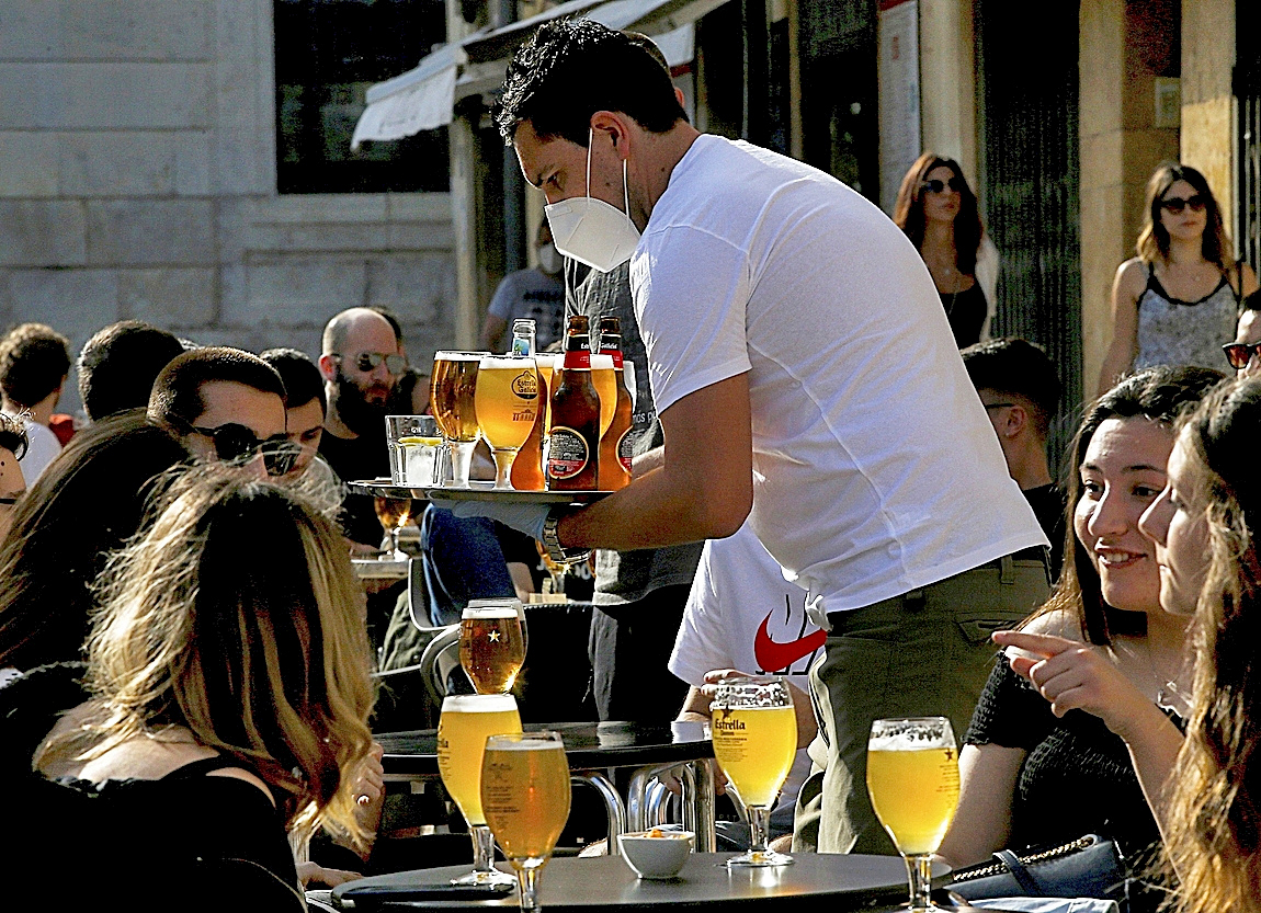 Un camarero sirve cervezas en una terraza en Madrid