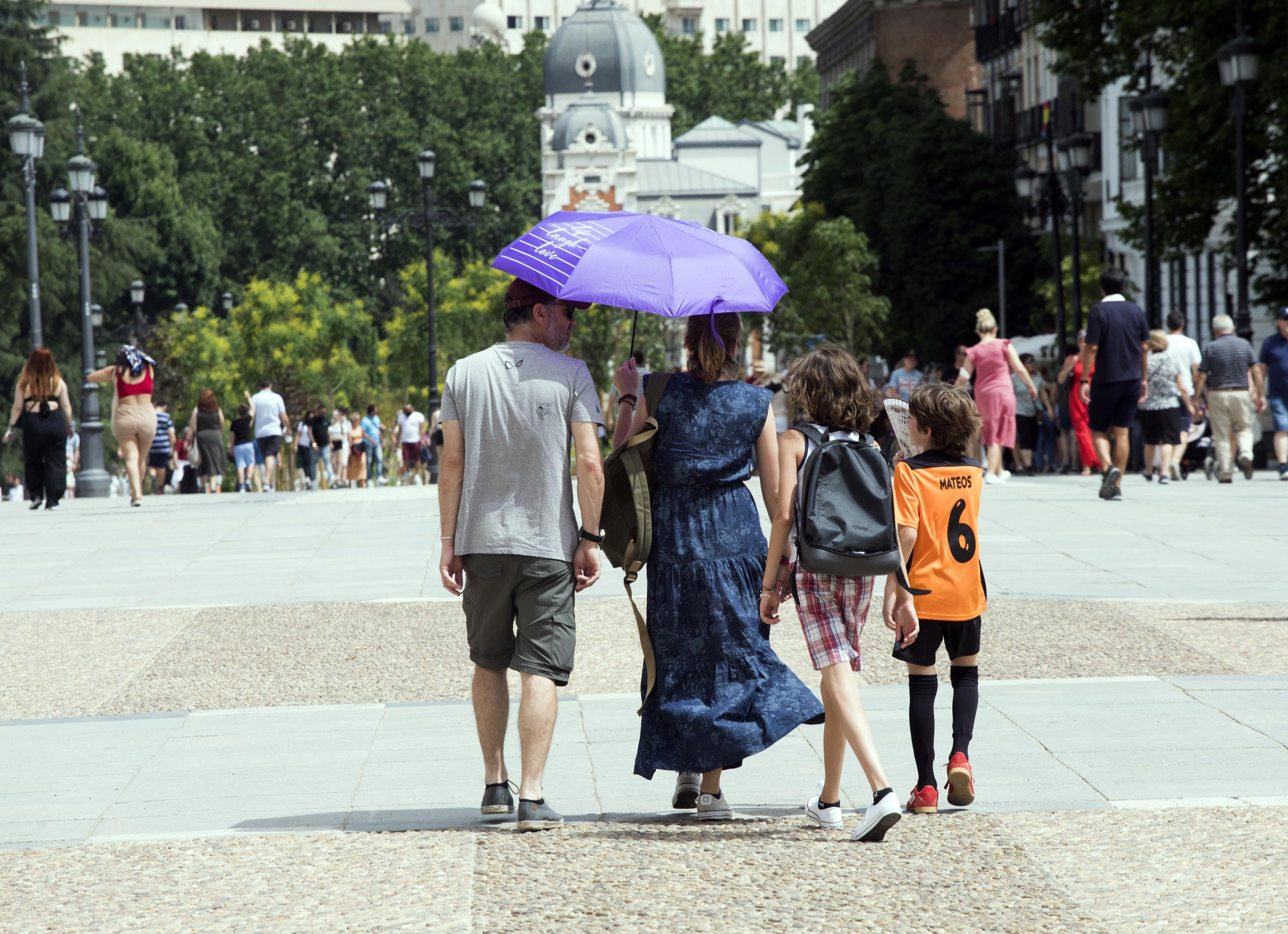 Una familia se protege del sol con un paraguas.