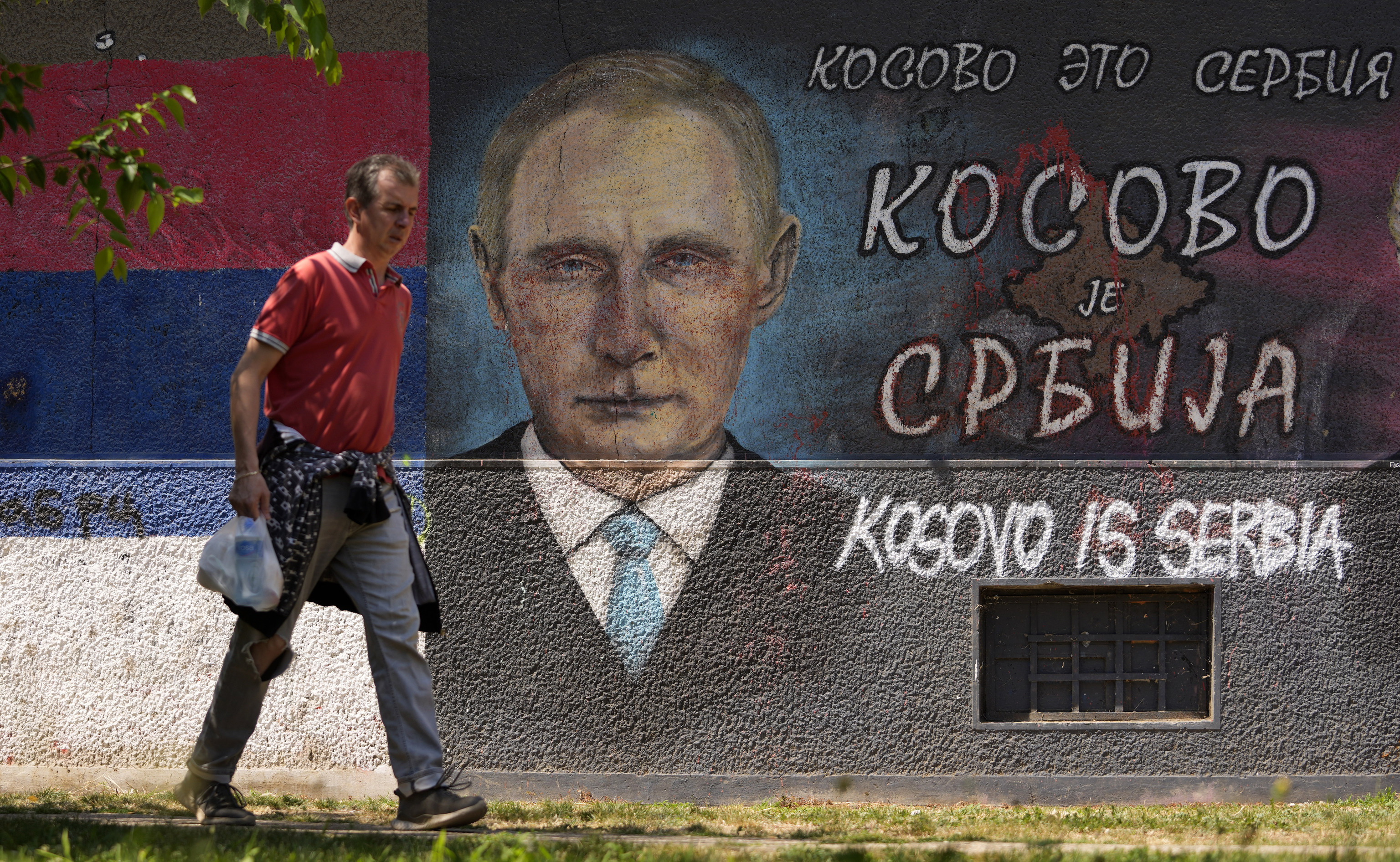 Un hombre pasea frente a un graffiti que reivindica que 'Kosovo es Serbia'.