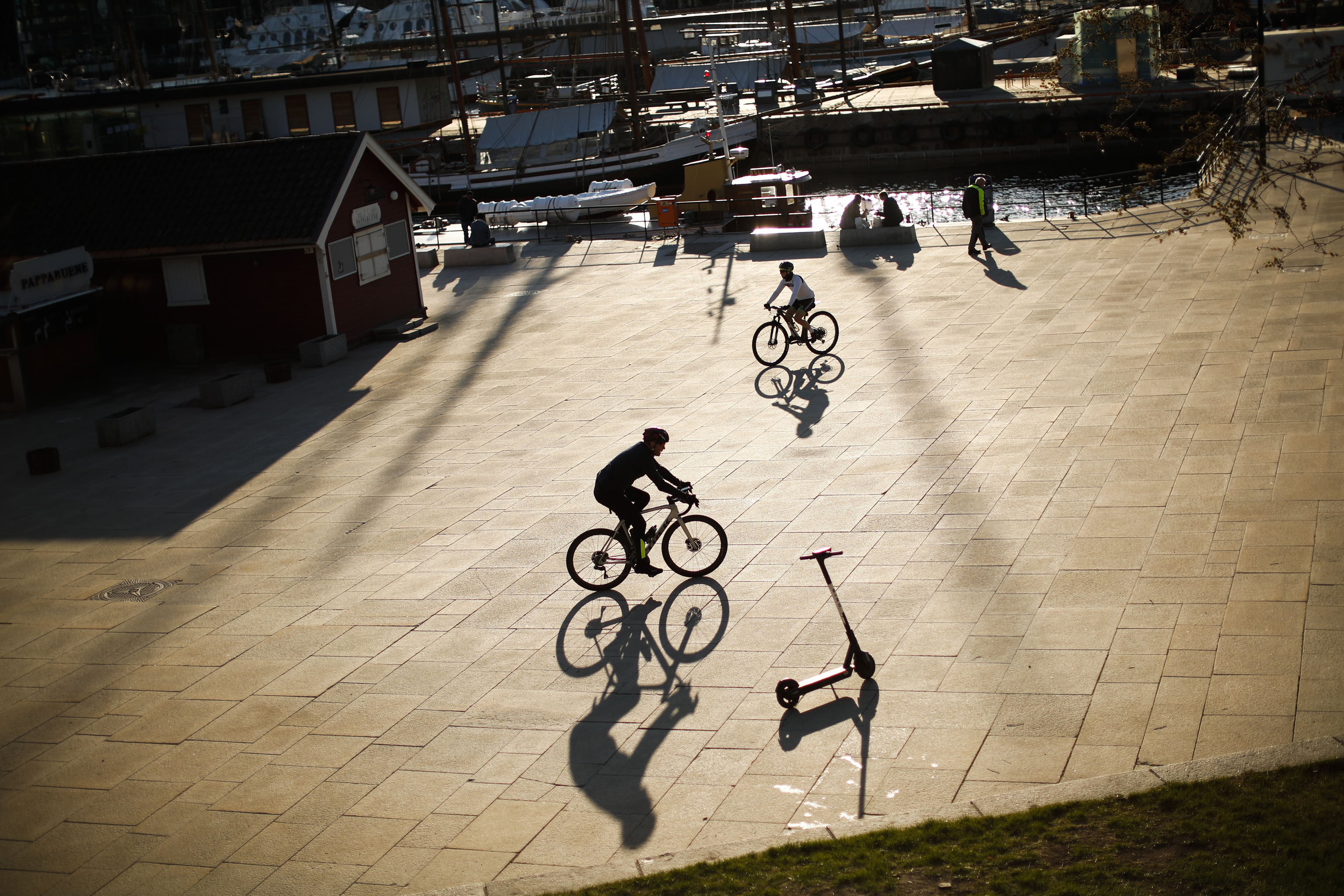 Ciclistas noruegos pedalean en una explanada de la marina del puerto de Oslo.