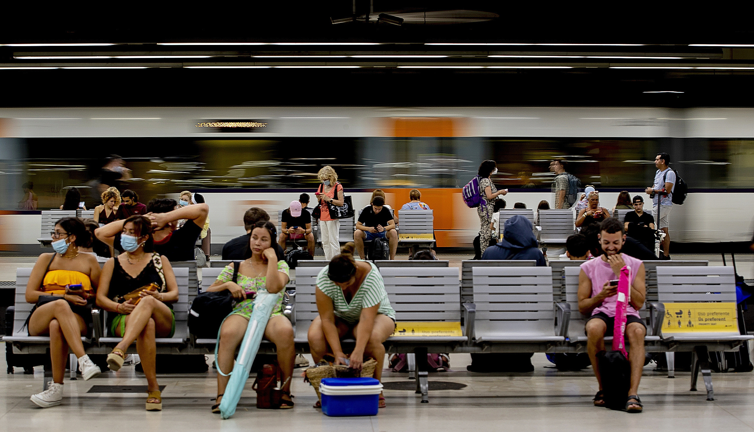 Un grupo de personas espera el Rodalies en la estación de Sants, en Barcelona.