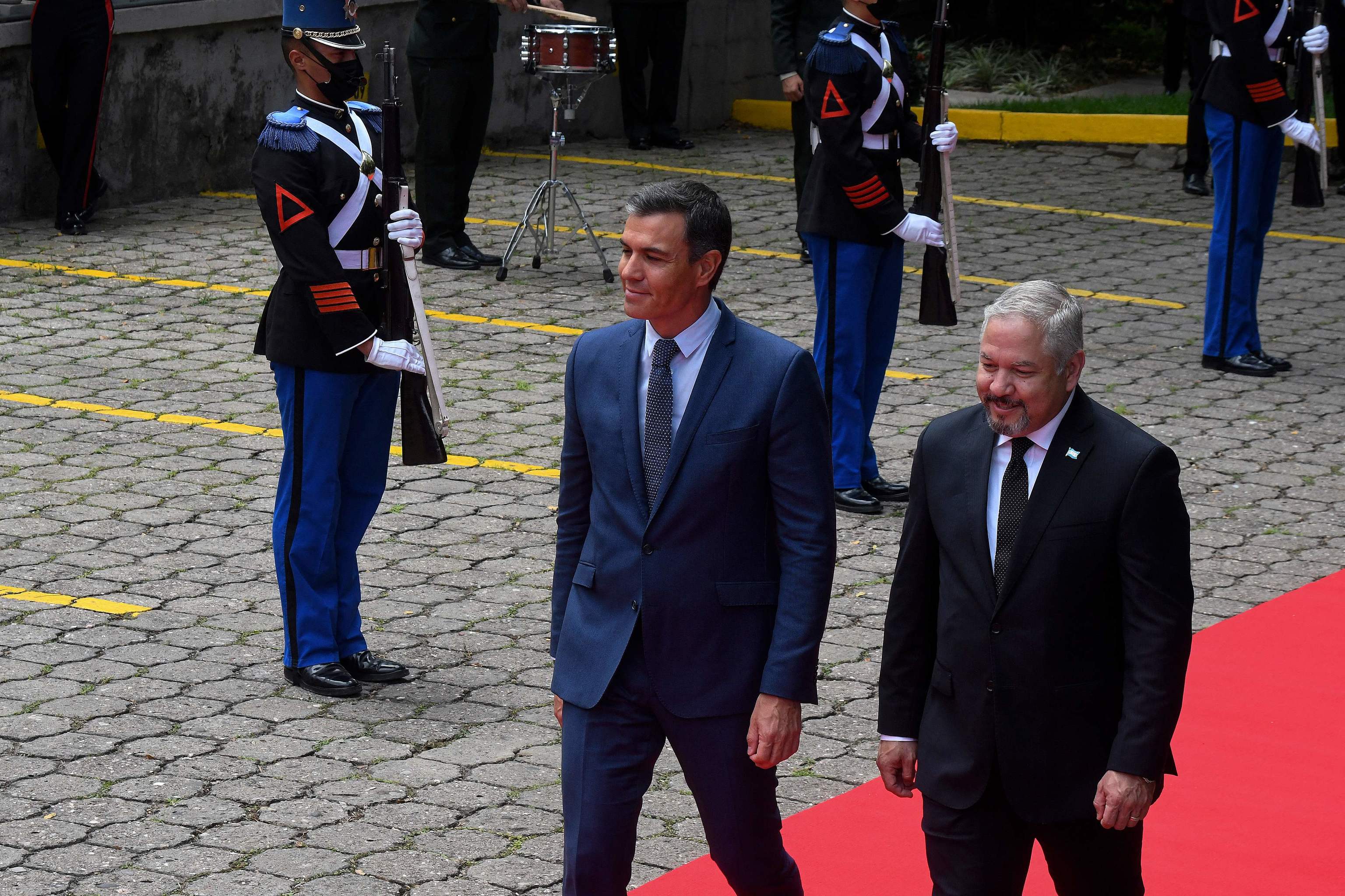 Pedro Sánchez camina junto al ministro de Exteriores hondureño, Eduardo Enrique Reina, durante una ceremonia en Tegucigalpa.