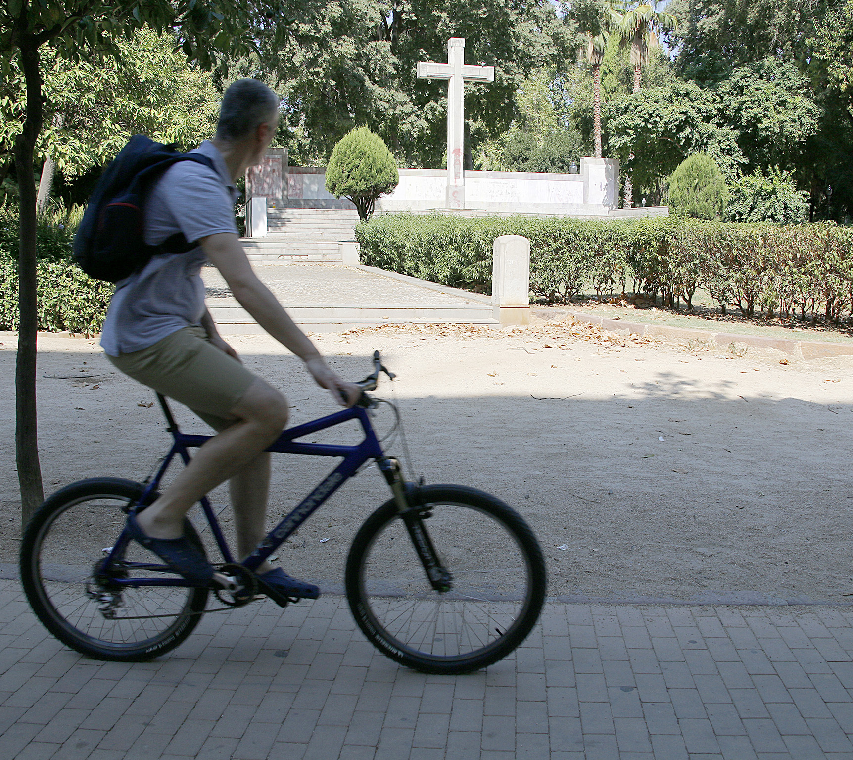 Un ciclista pasa por delante de la Cruz en el parque Ribalta.