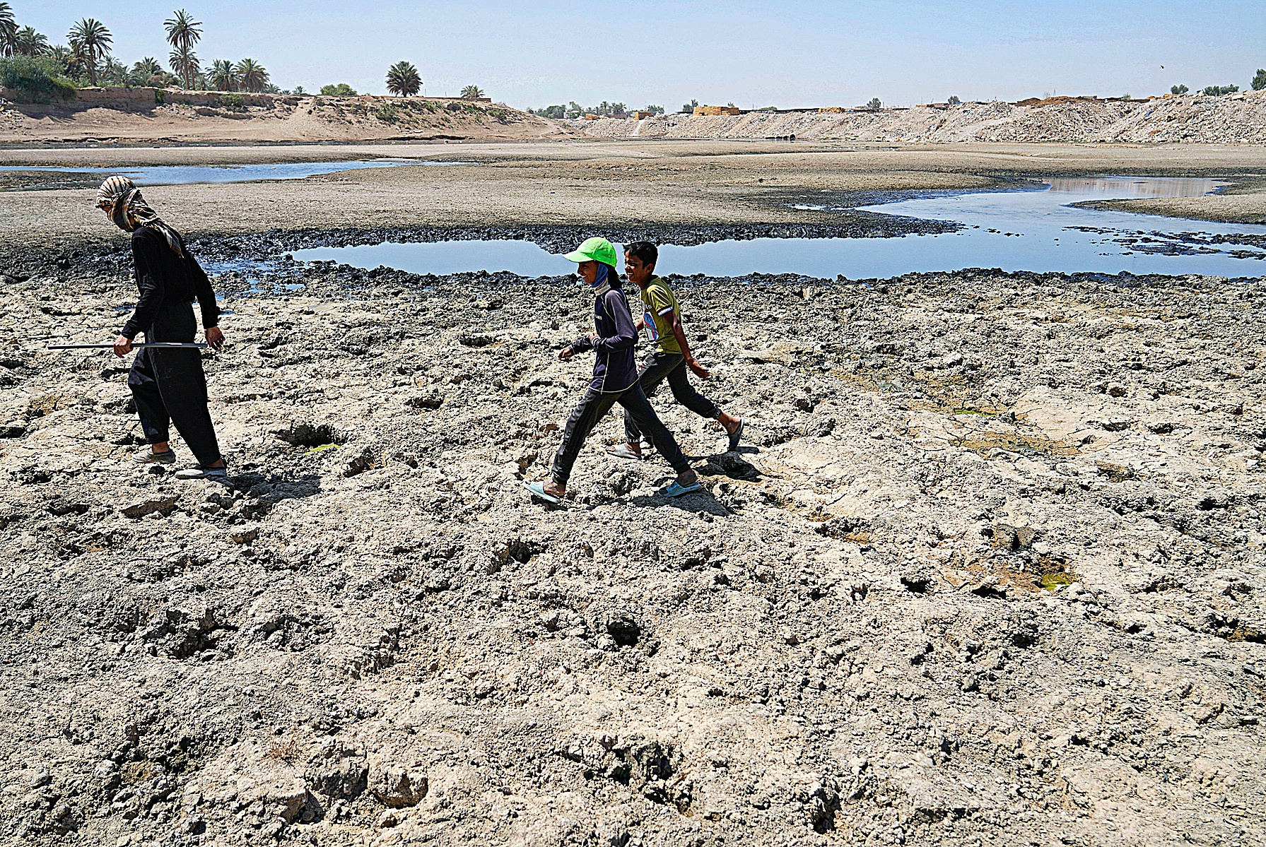 Unos nios cruzan el ro Diyala, afluente casi seco del ufrates.