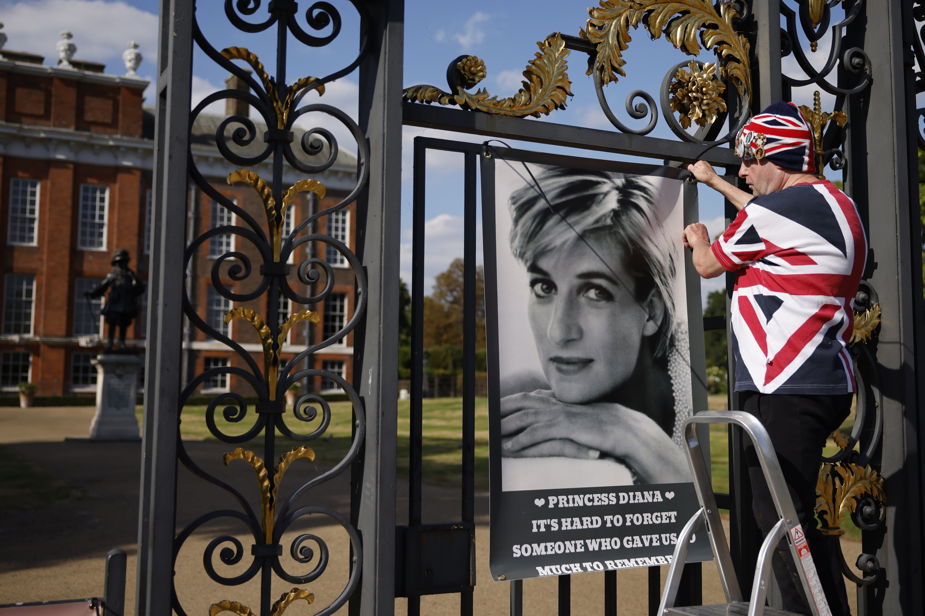 Un fan, con un cartel de Diana en el Palacio de Kensington.