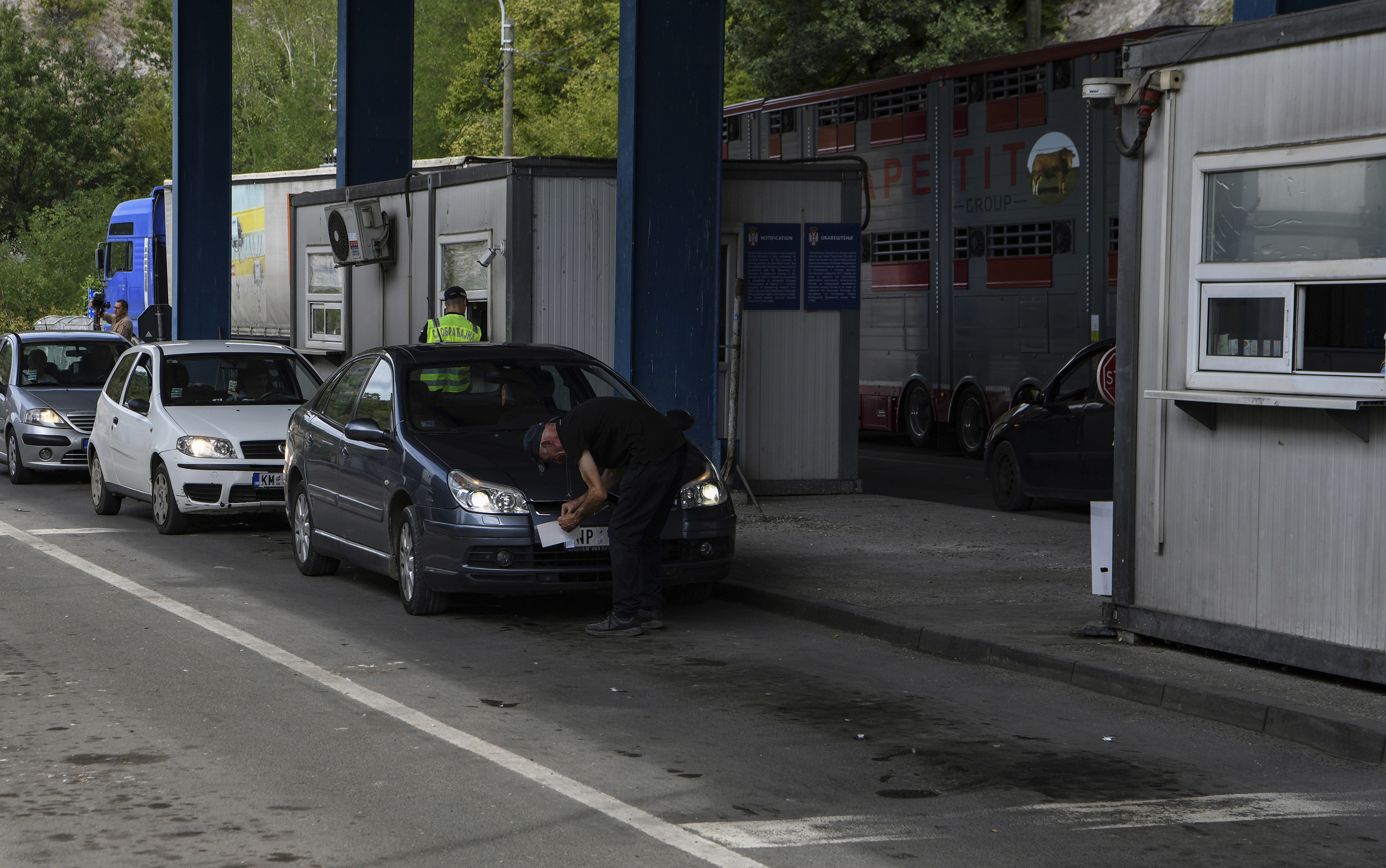 Un hombre tapa la matrcula serbia para poder entrar a Kosovo.