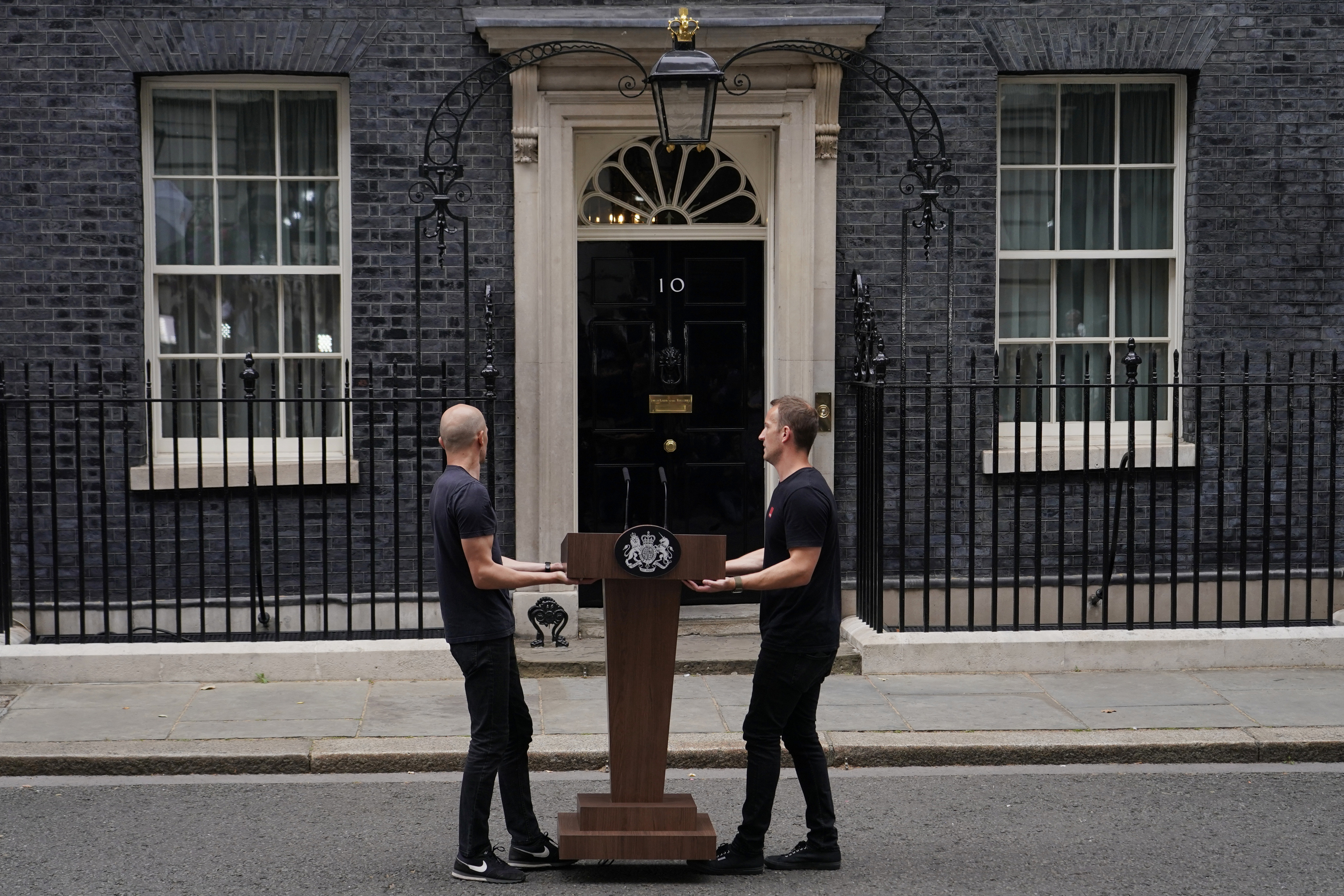 Operarios instalan un atril en Downing Street.