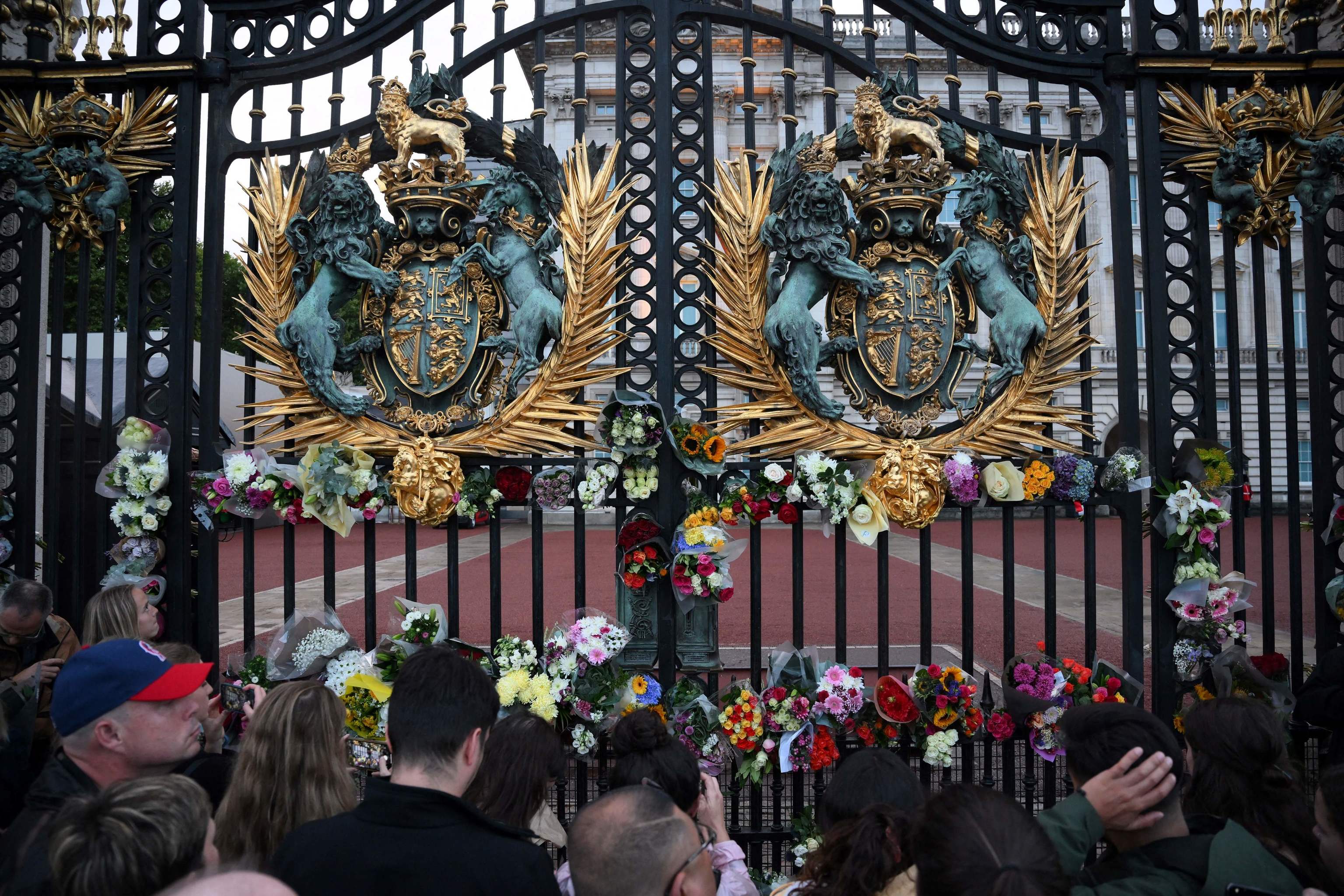 La gente deja ramos de flores en el Palacio de Buckingham.
