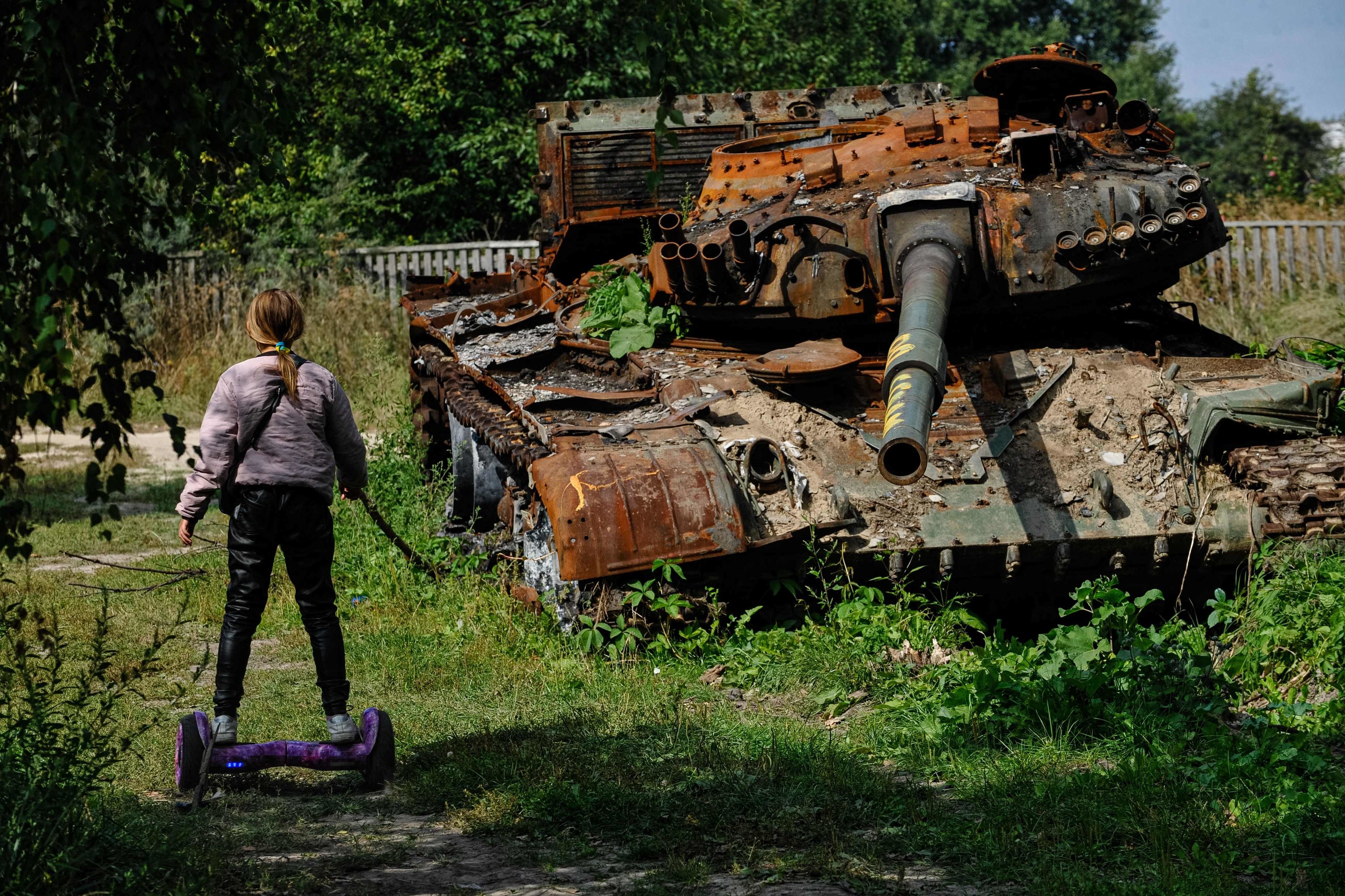 Una adolescente contempla un tanque de Rusia destruido en Ucrania