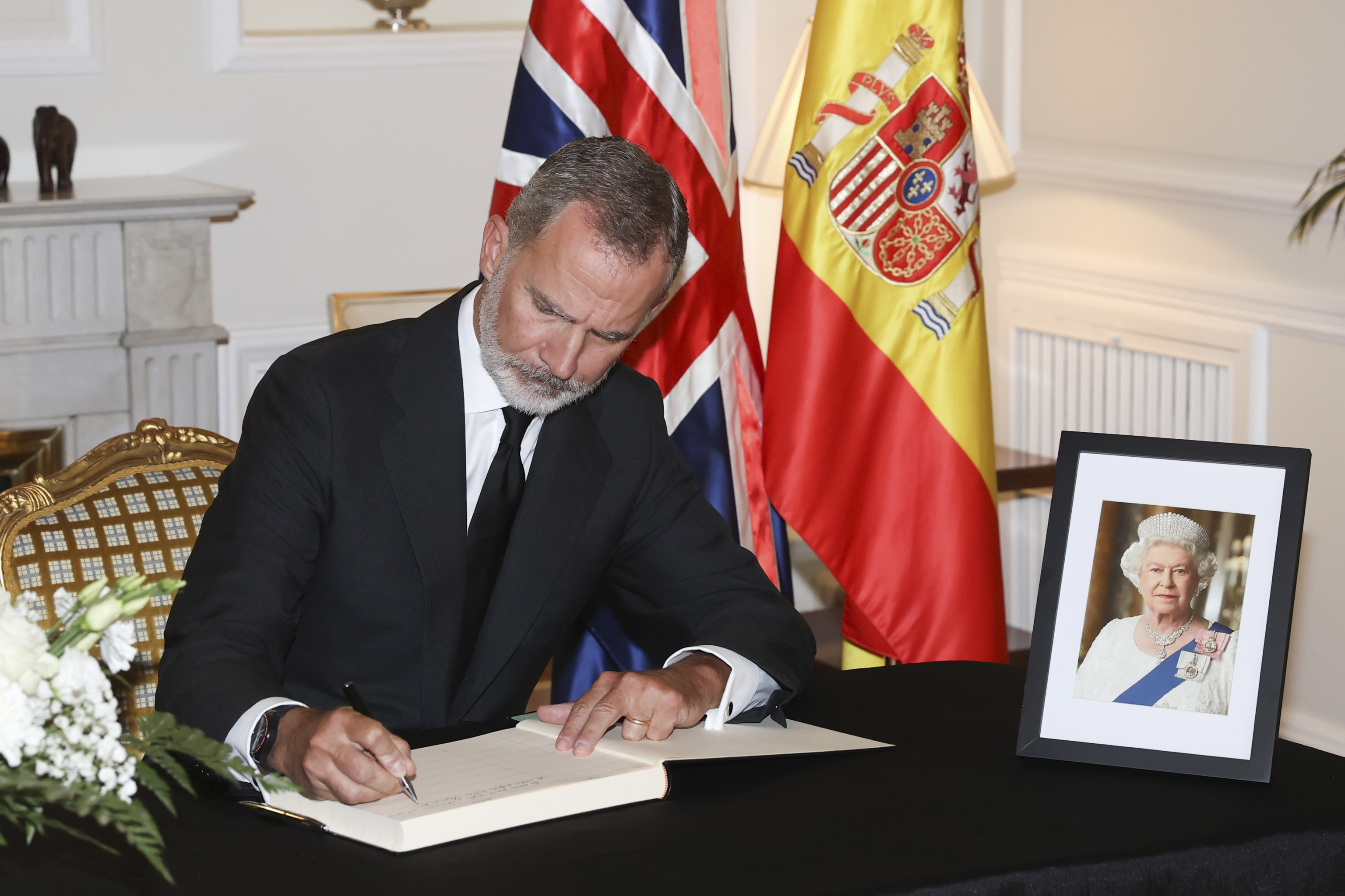 Felipe VI firma en el libro de condolencias en la residencia del embajador británico en Madrid.