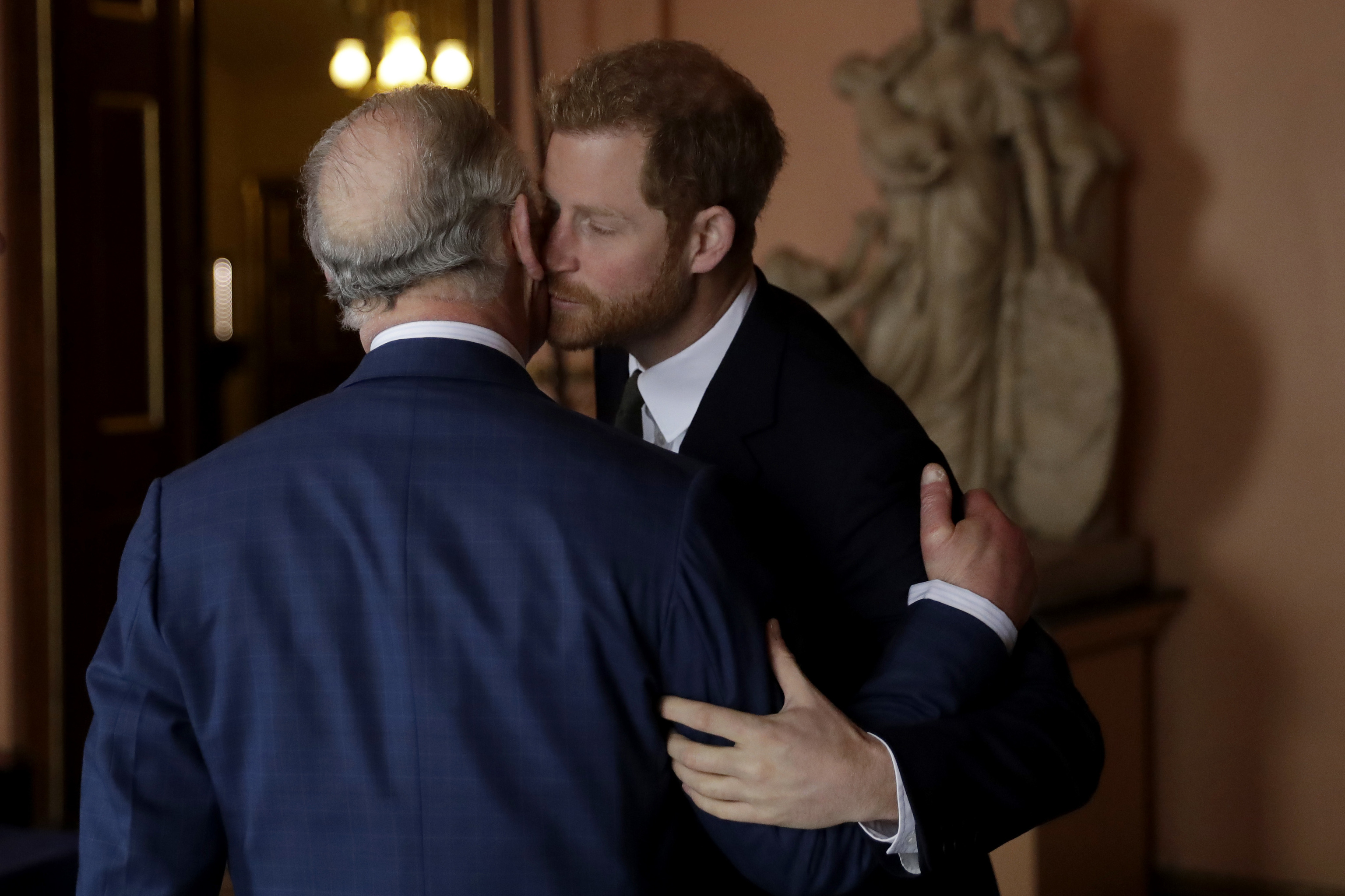 El prncipe Harry saluda a su padre durante un acto pblico.