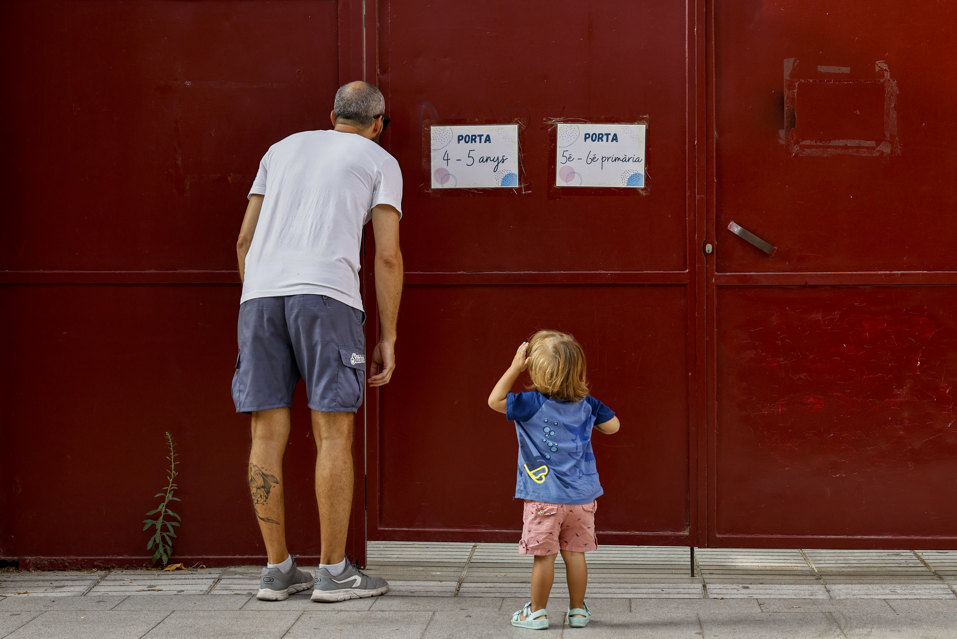 Un padre, con su hija, a las puertas de un colegio.