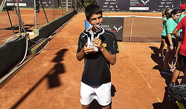 Alcaraz muerde un trofeo como Rafa Nadal ganado en su academia.